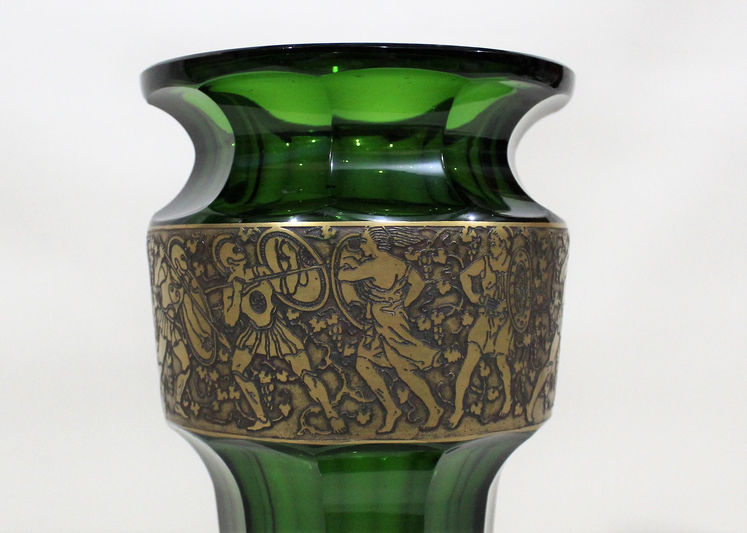 Vase Art Nouveau en verre taillé vert émeraude sur piedouche avec une frise dorée en relief de soldats romains et de déesses entourés de guirlandes de raisins.

  