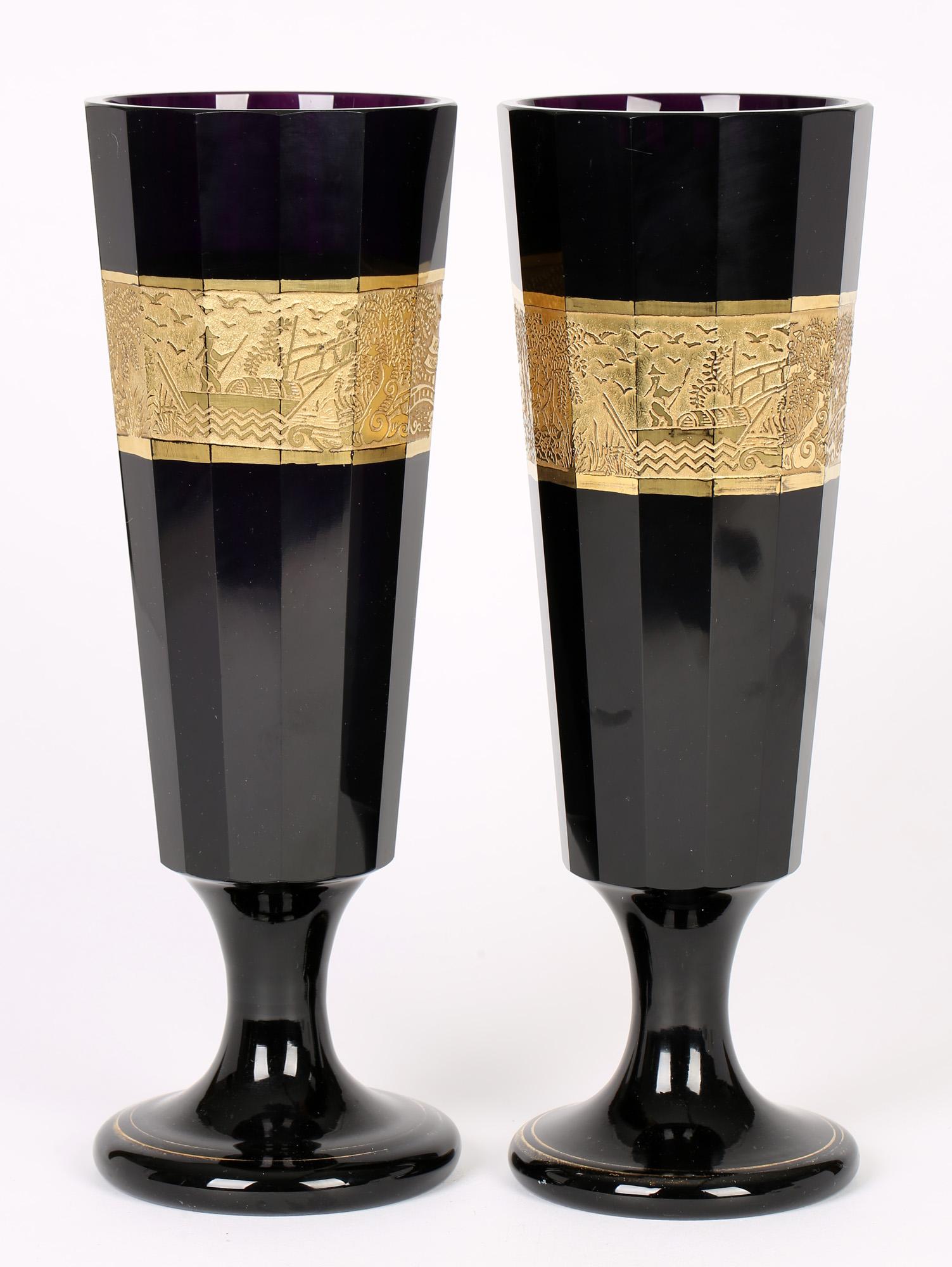 An exceptional and large pair Moser amethyst glass vases with gilded chinoiserie patterns dating from around 1910. These tall glass vases Stand on a wide rounded solid pedestal foot with a short narrow stem and with a tall slender body with multiple