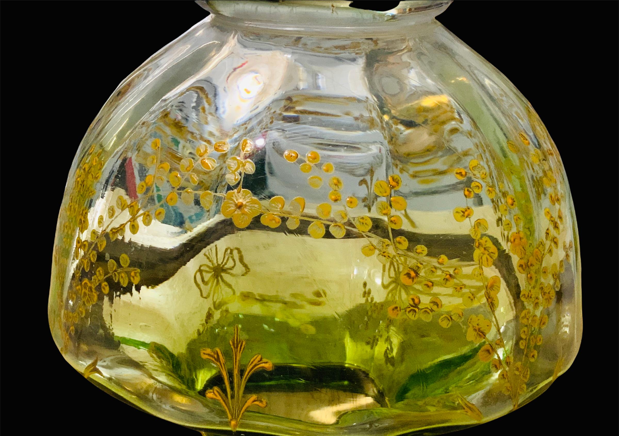 Ce vase en forme d'urne est un centre de table en verre doré et de couleur vert clair de Moser. Il est décoré de branches et de nœuds de fleurs peints à la main en or et en jaune, façon 