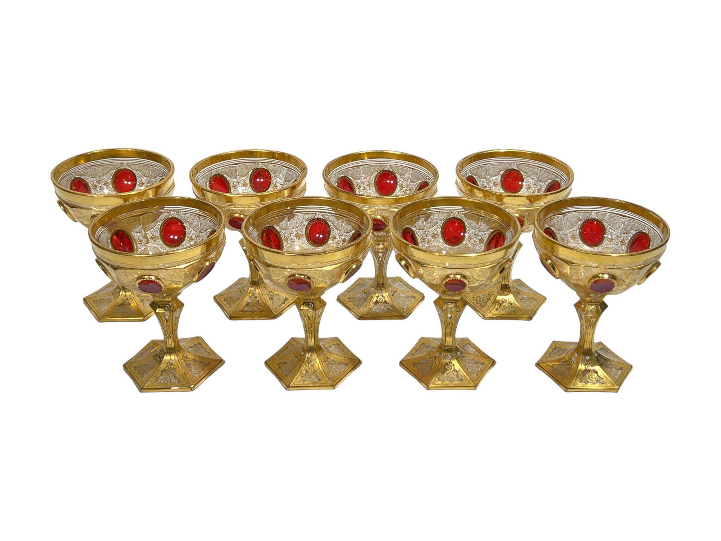 Our lovely set of eight champagne coupes attributed to Moser are distinguished by their fine and delicate gilt decorations and ruby red cabochons.  Each 4 3/4 inches tall.  