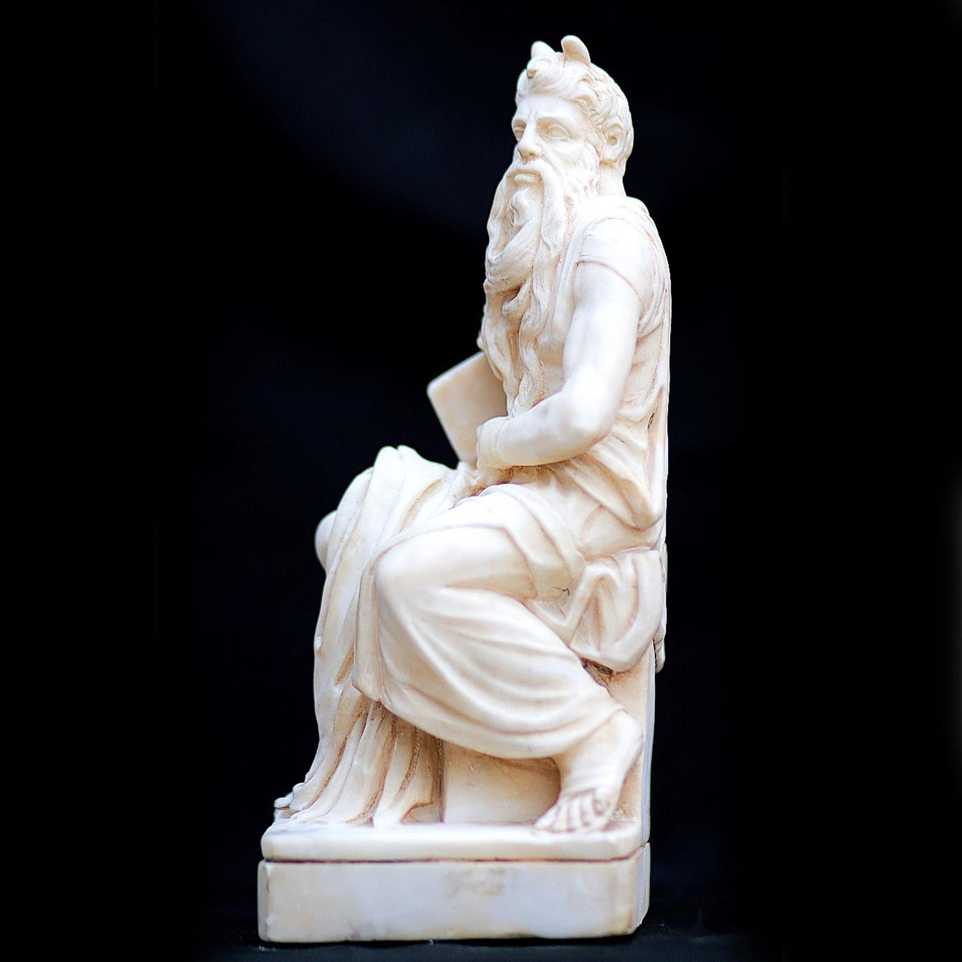 This alabaster work recreates one of the most famous statues of Renaissance Italy, Michelangelo's Moses. The bearded prophet is seated with his head facing left. His right foot is resting squarely on the ground, while the left one is dynamically