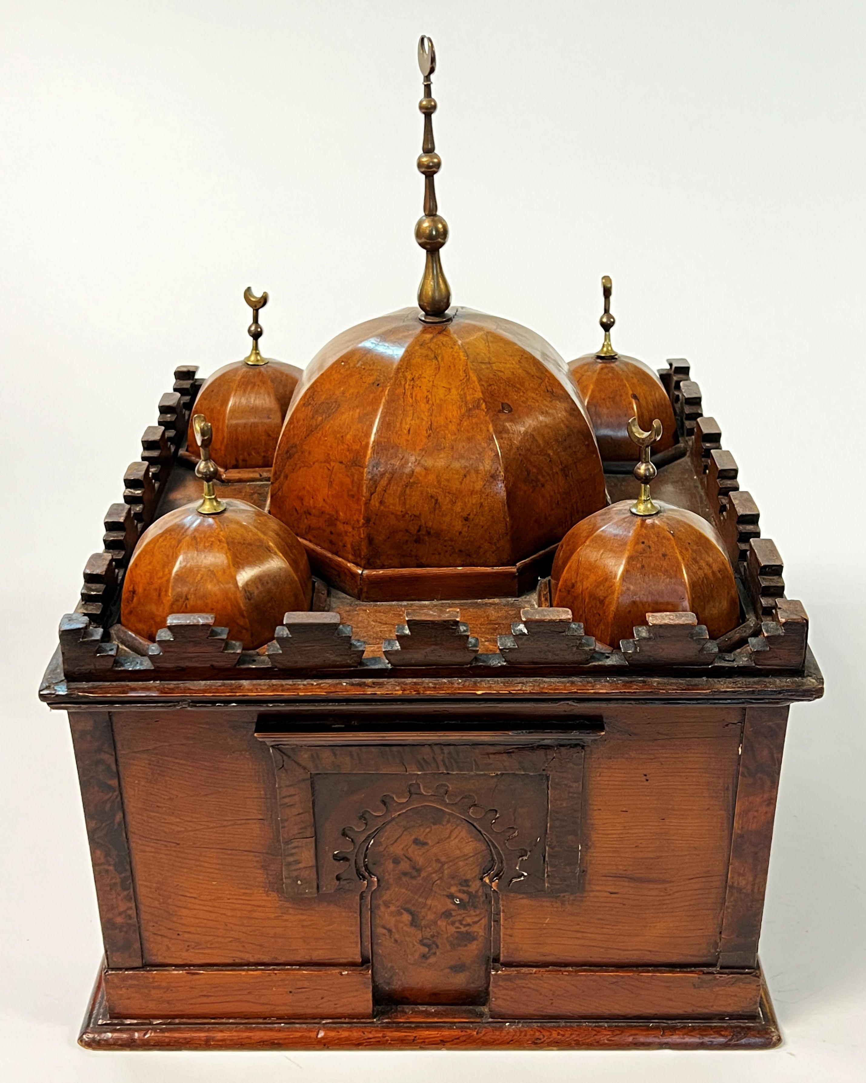 Our charming and rare cellaret in the form of a mosque is crafted from fruitwood and brass. It has a center dome and four smaller domes each decorated with brass crescent moons, each removeable to reveal compartments below to accommodate up to five