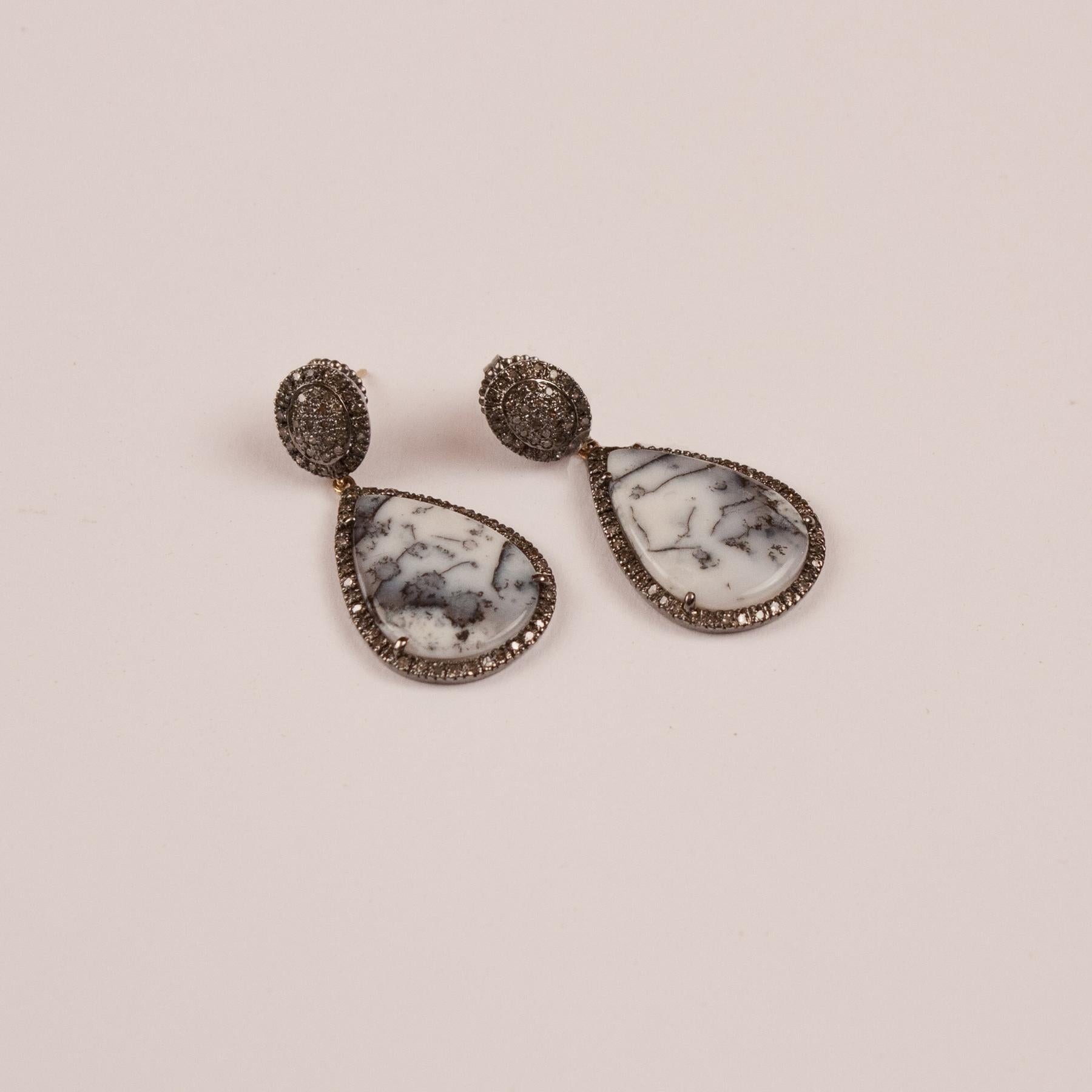 Moss agate drops, framed by pave set diamonds, suspend from round diamond studs. The cabochon agate slices in these dangle earrings have beautiful inclusions and a subtle palette.
Agate: 20.90 ct
Diamond: 1.65 ct  