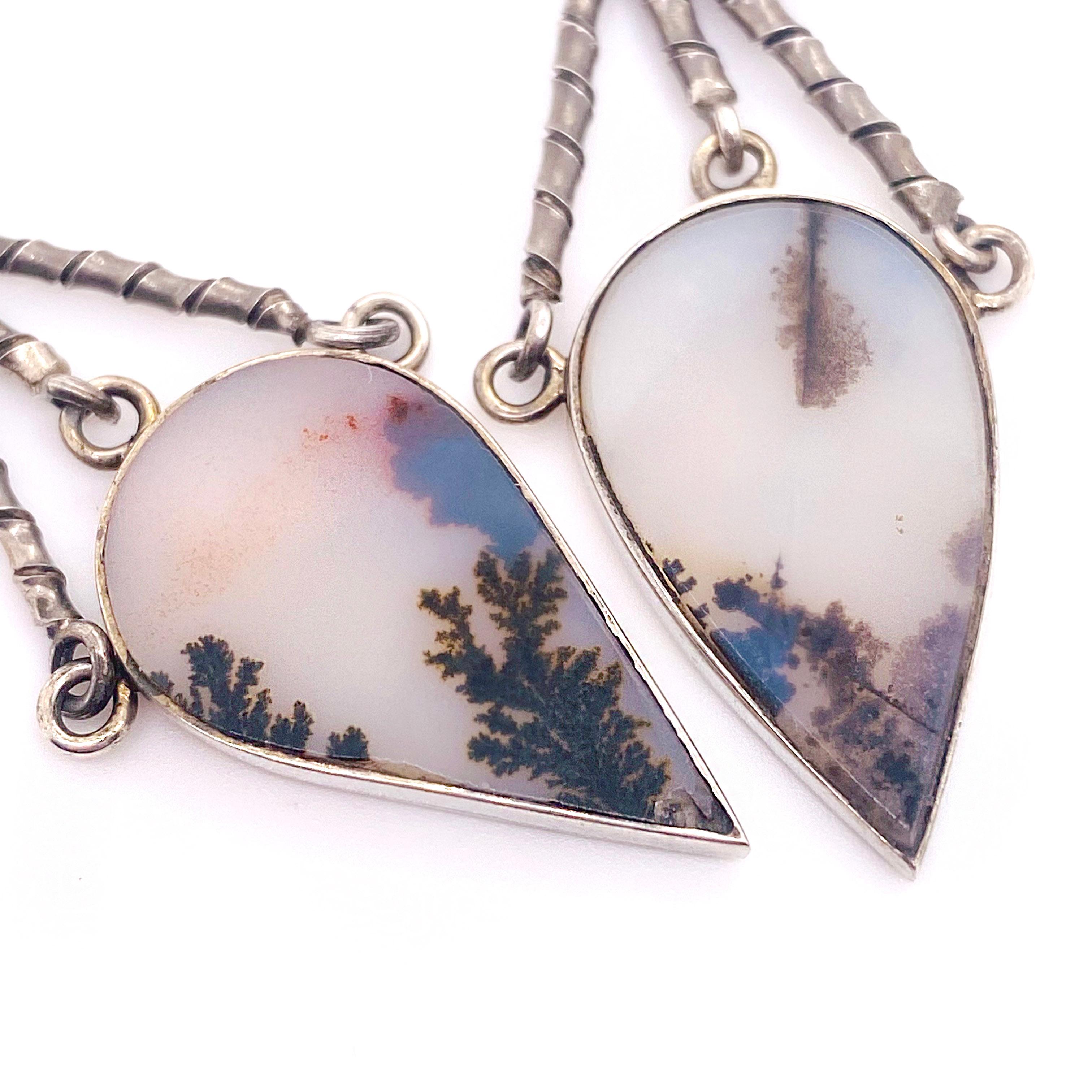 The moss agate organic earrings were made by our jewelers in our shop. The white agate has the moss inside that looks like a cedar branch. The earrings have a sterling ball at the top and has three twisted sterling bars that dangle down to a pear