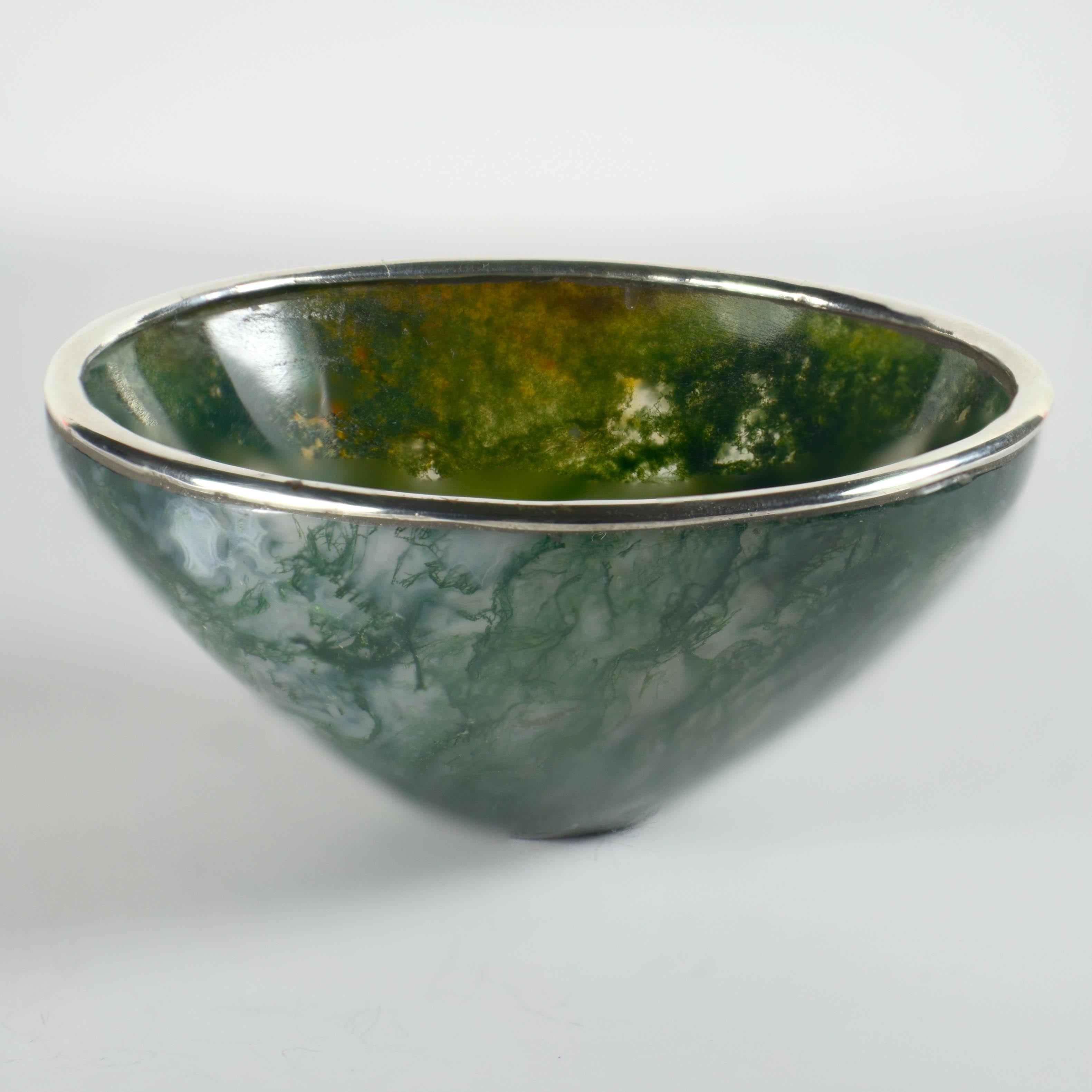 A charming bowl carved out of moss agate with a silver metal ring. Unmarked.
Diameter 3