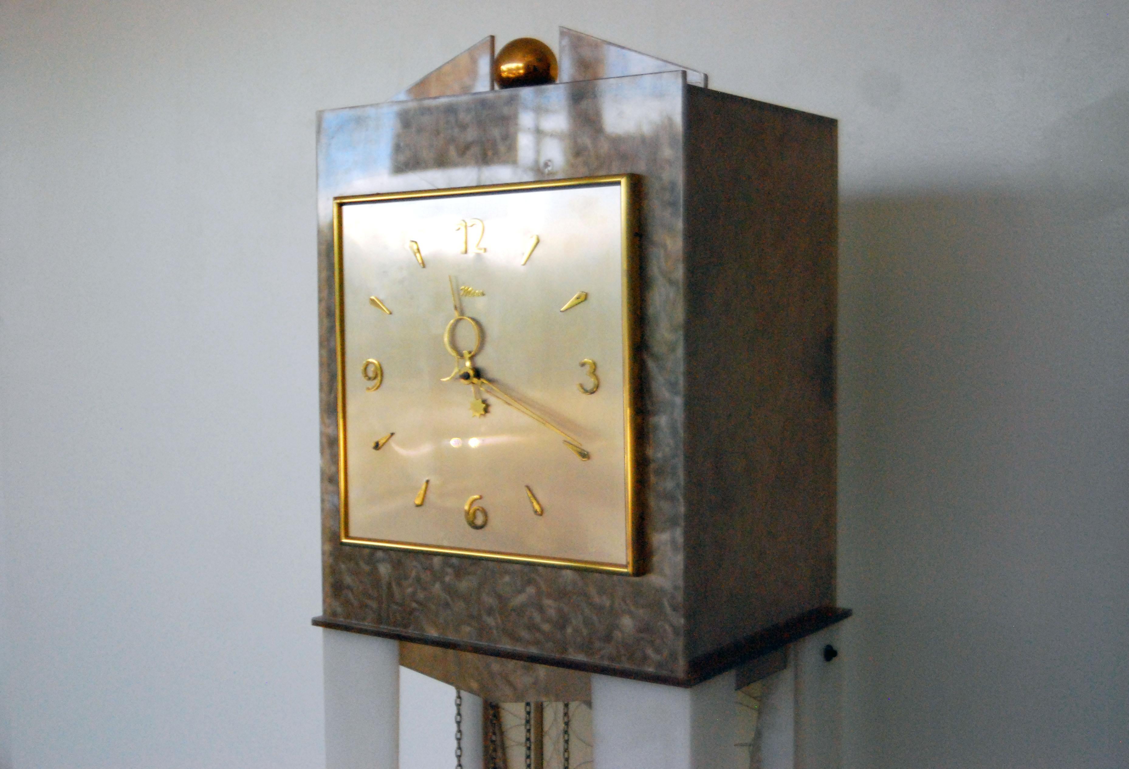 Designer: Moss
Manufacture: Moss 
Period/style: Mid-Century Modern 
Country: US 
Date: 1950s.

Working grandfather clock with built in light.