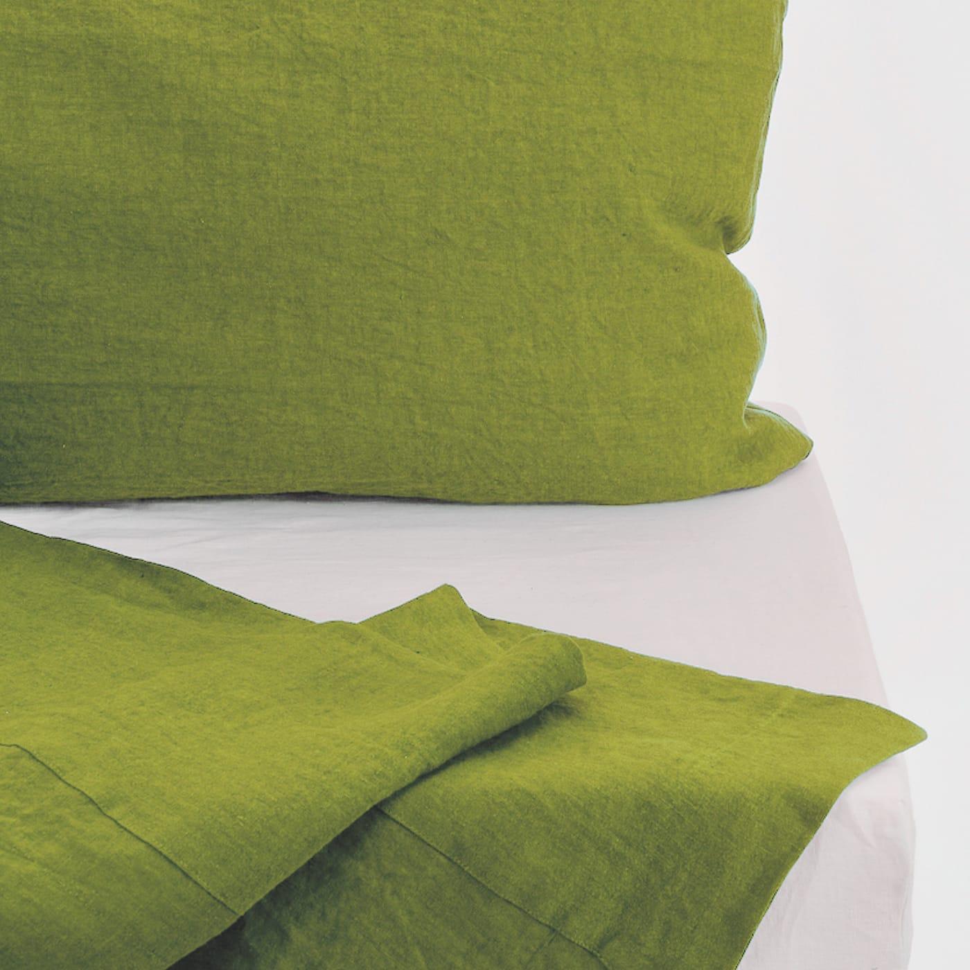 Dieses elegante und farbenfrohe Set, das vollständig aus feinstem Leinen handgefertigt ist, besteht aus einem Oberlaken mit passenden Kissenbezügen, die in einem raffinierten Moosgrün gefärbt sind, und einem weißen Spannbettlaken, das für eine 30 cm