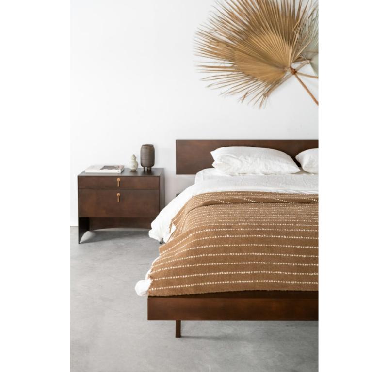 The patinated finish on the Mossam Bed is meticulously developed to enhance the bed's industrial charm while infusing it with an air of time-worn allure. The patina lends a distinctive, weathered character to the steel, making each bed a