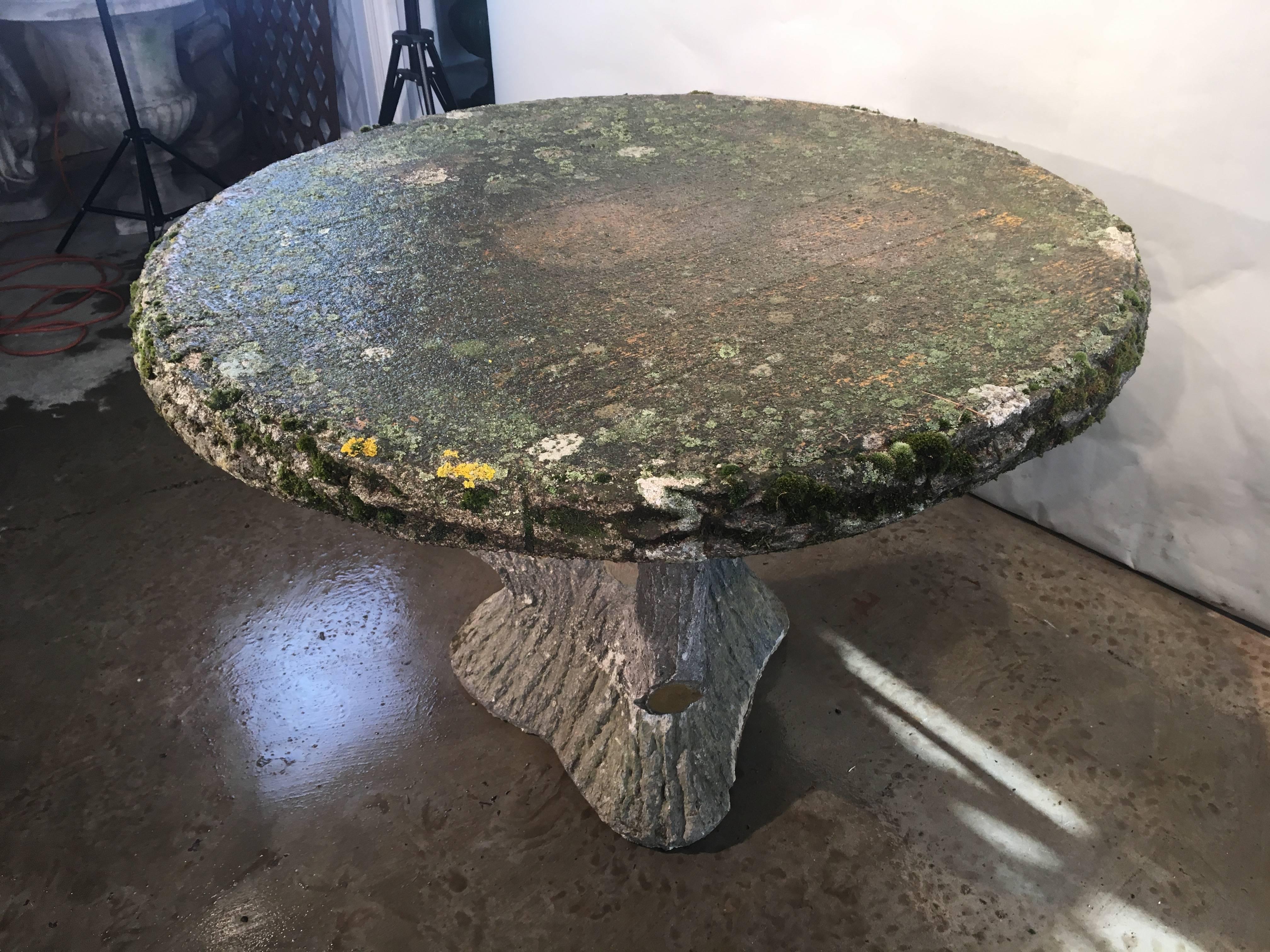 We bought this marvelous weathered round faux bois table because of its incredible mossy and lichened surface, 2.75 inch thick top, and curvaceous base. The table has had a small chip to the base restored, and we have now included photos of the