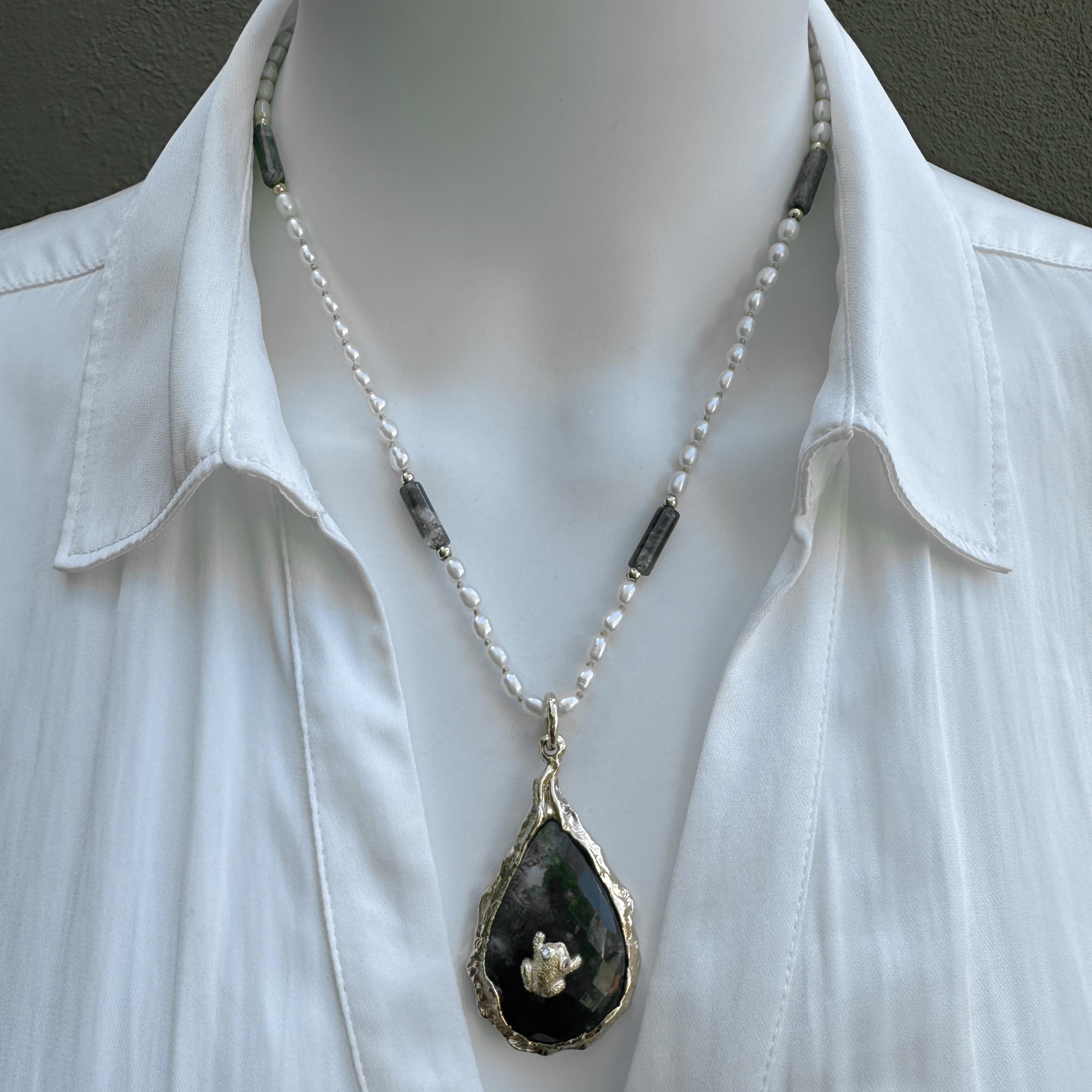 What to do with a little 14 karat frog that's been hopping around the store for so long no one remember where he came from?

Answer?  Attach him to the kind of gemstone a frog will love: a big drop-shaped faceted cabochon of moss agate.  This is a