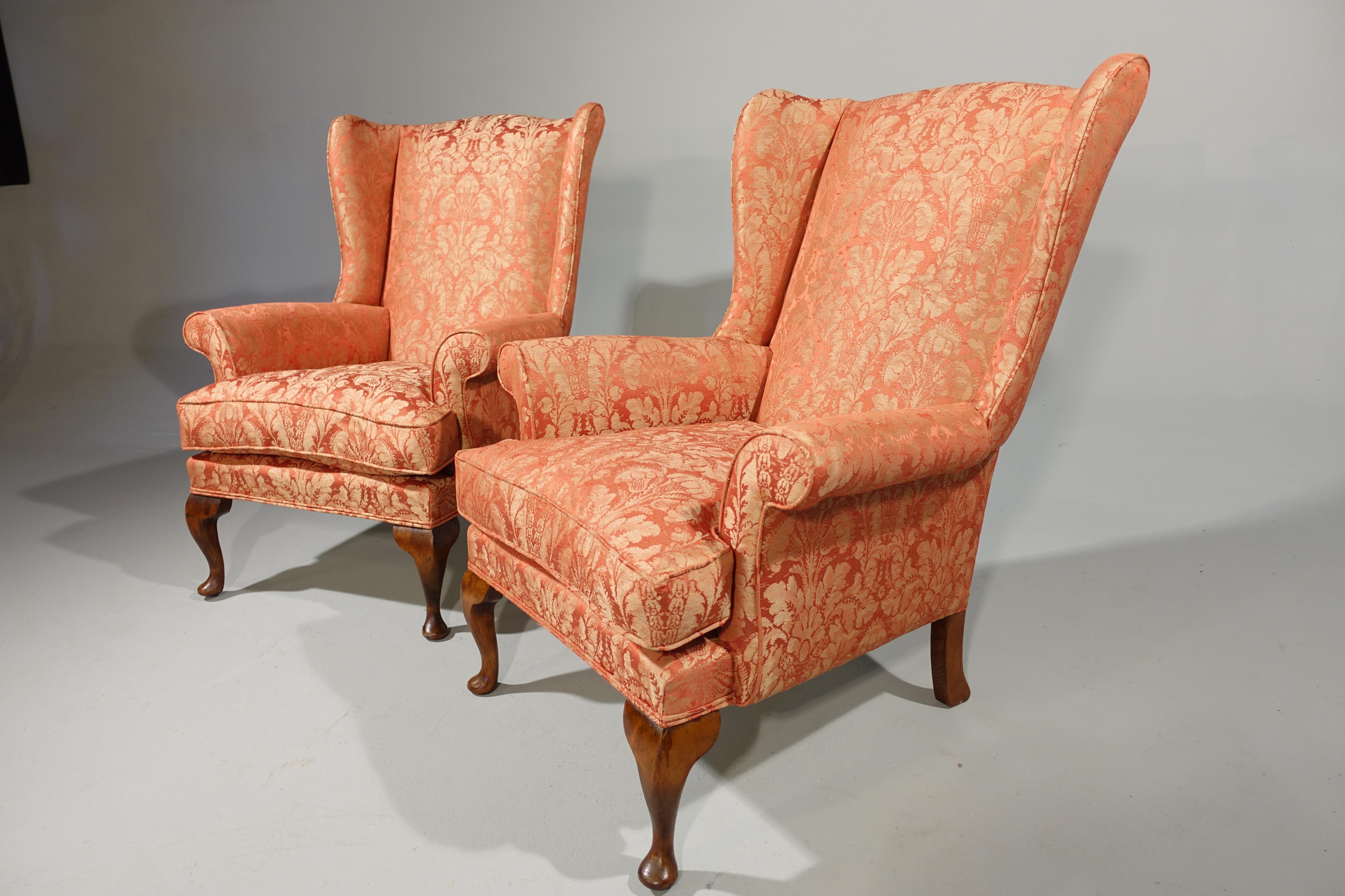 A most attractive pair of George II style walnut framed wing chairs. The wings particularly slender and flared. Now totally reupholstered in our own workshop in a Gainsborough classical damask.