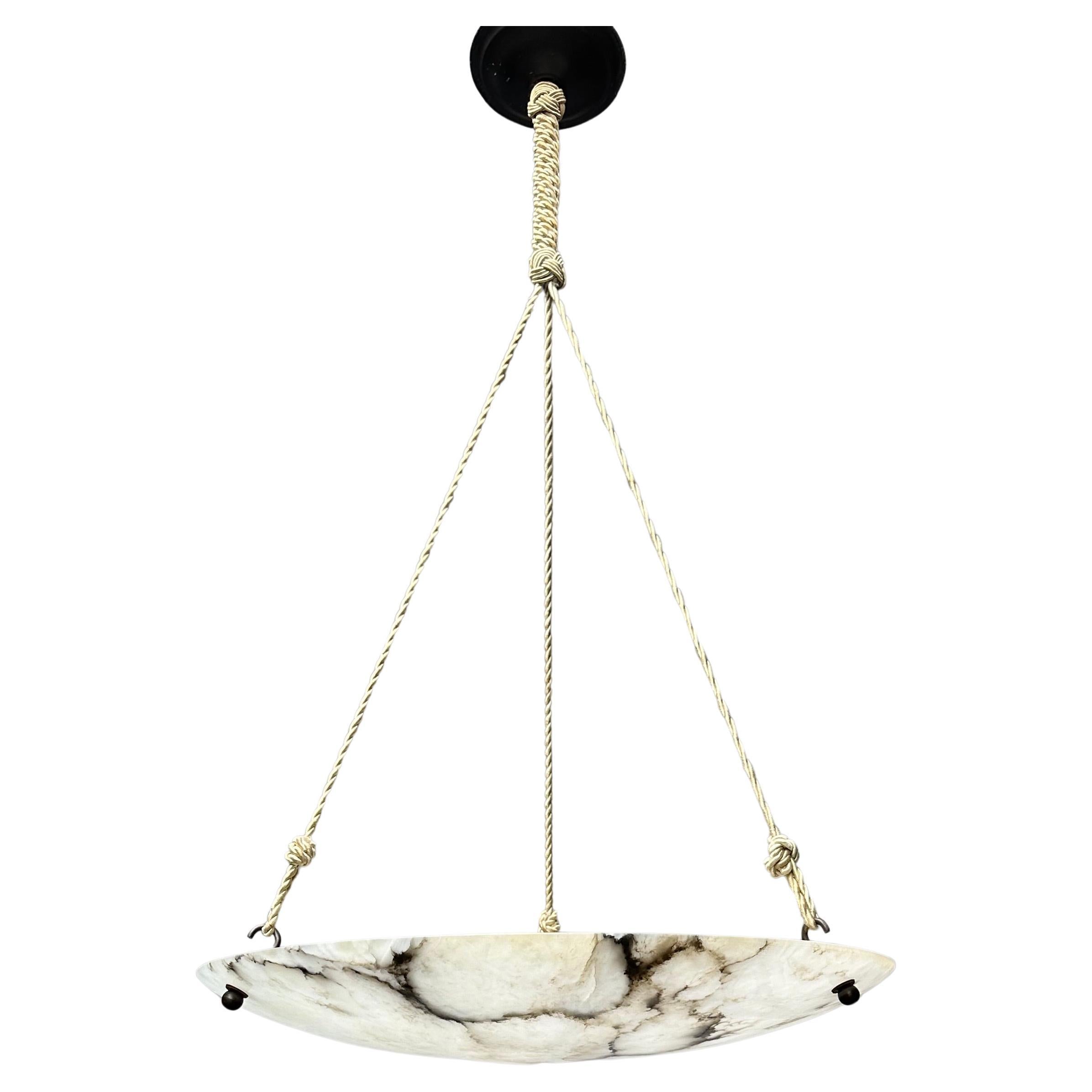 Large antique alabaster chandelier, from the early 1900s.

This rare, almost flat and large size alabaster light fixture also is of a beautiful design. The stunning and superbly polished alabaster shade makes this impressive light fixture even more