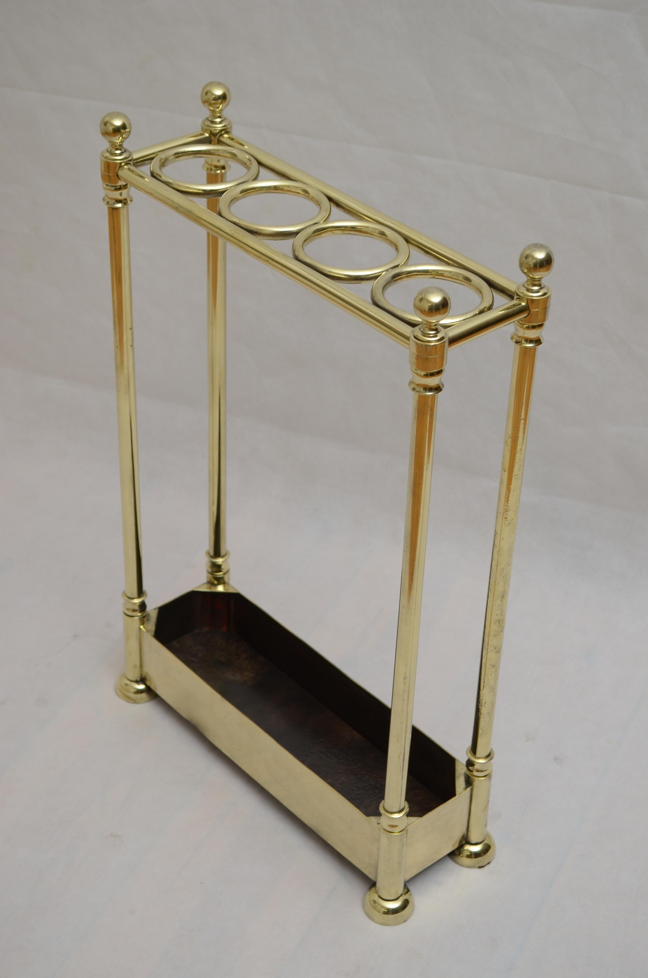 P0284 Superbe porte-parapluies ou porte-manteau du XIXe siècle, à quatre compartiments flanqués de fleurons décoratifs, reposant sur quatre montants terminés par un profond bac à eau et des pieds en chignon d'origine. Ce porte-parapluie ancien a été