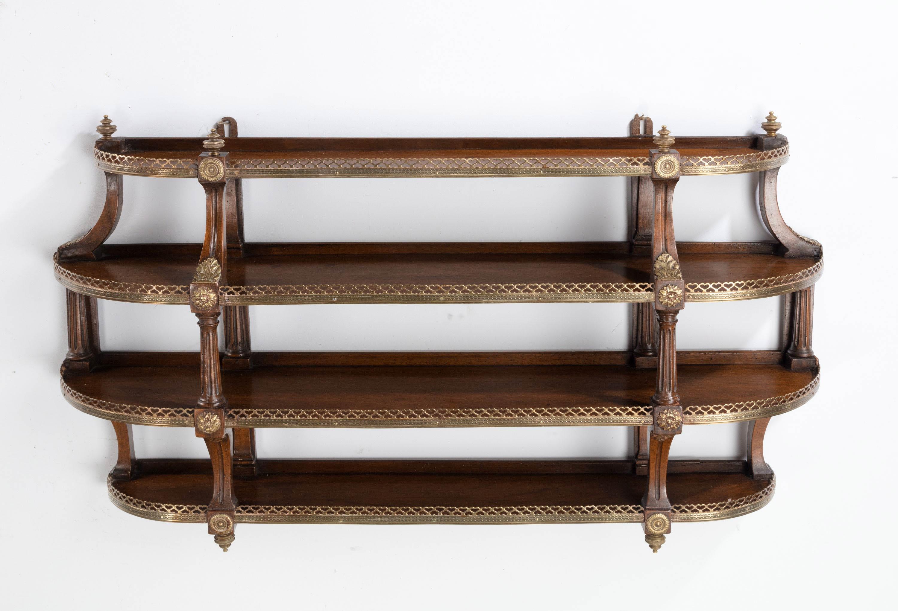 A most unusual pair of four height, mahogany wall shelves with very finely cast galleries. The shelves retaining their original surfaces.
    