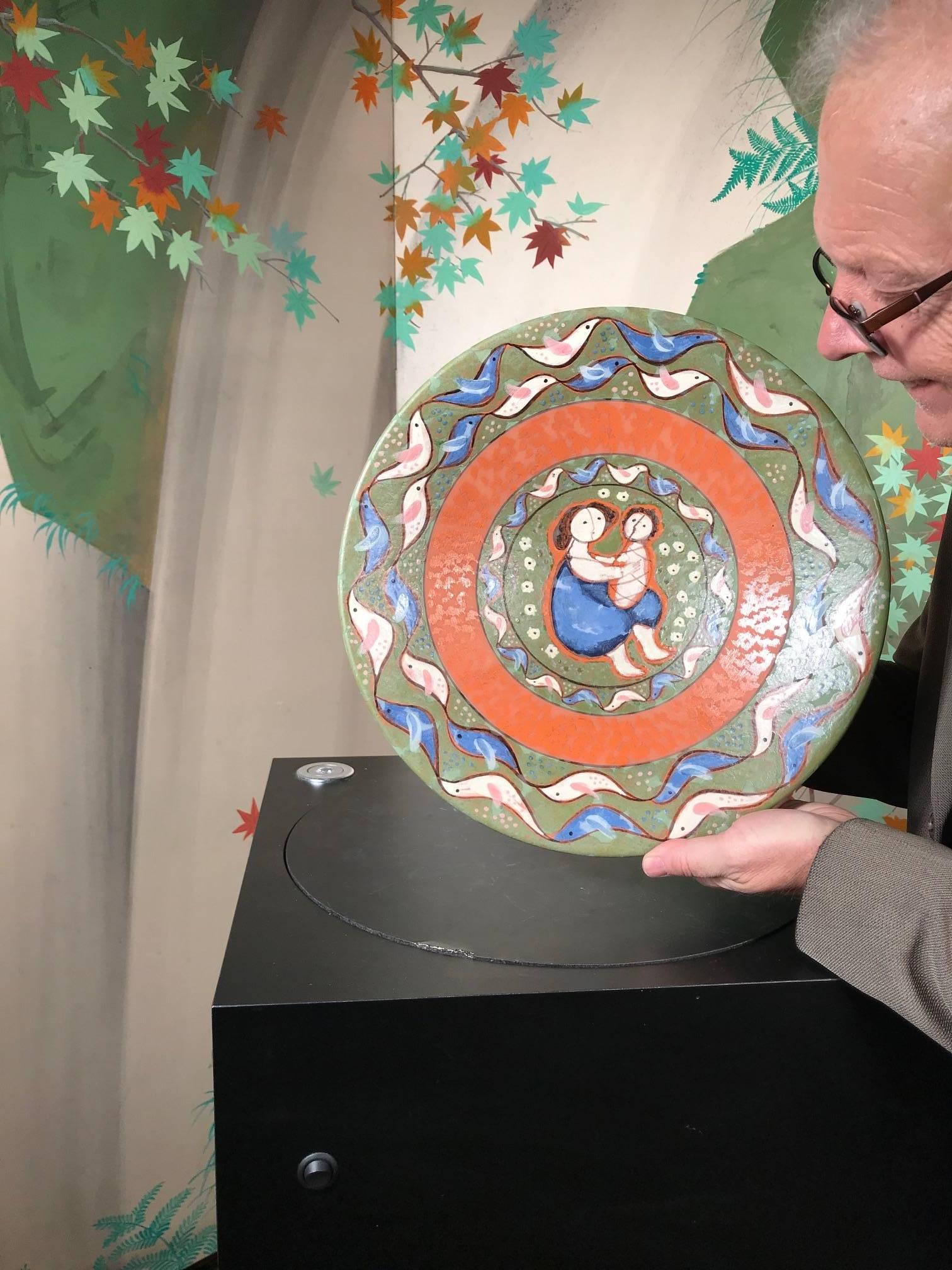This is a wonderful handmade, hand-painted and hand glazed charger featuring a wonderful -Mother and Child- theme surrounded by birds. It was designed and hand painted by the now deceased master artisan Eva Fritz-Lindner working at the Karlruhe over