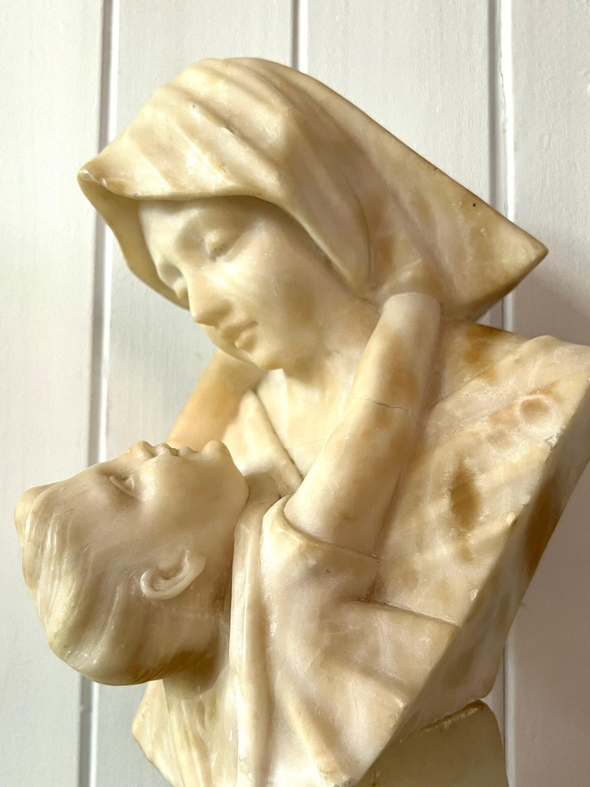 Nous vous présentons un captivant buste en albâtre sculpté représentant la mère et l'enfant, habilement réalisé pour capturer le moment de tendresse entre une jeune mère et son enfant. Cette pièce exquise présente des détails complexes et des