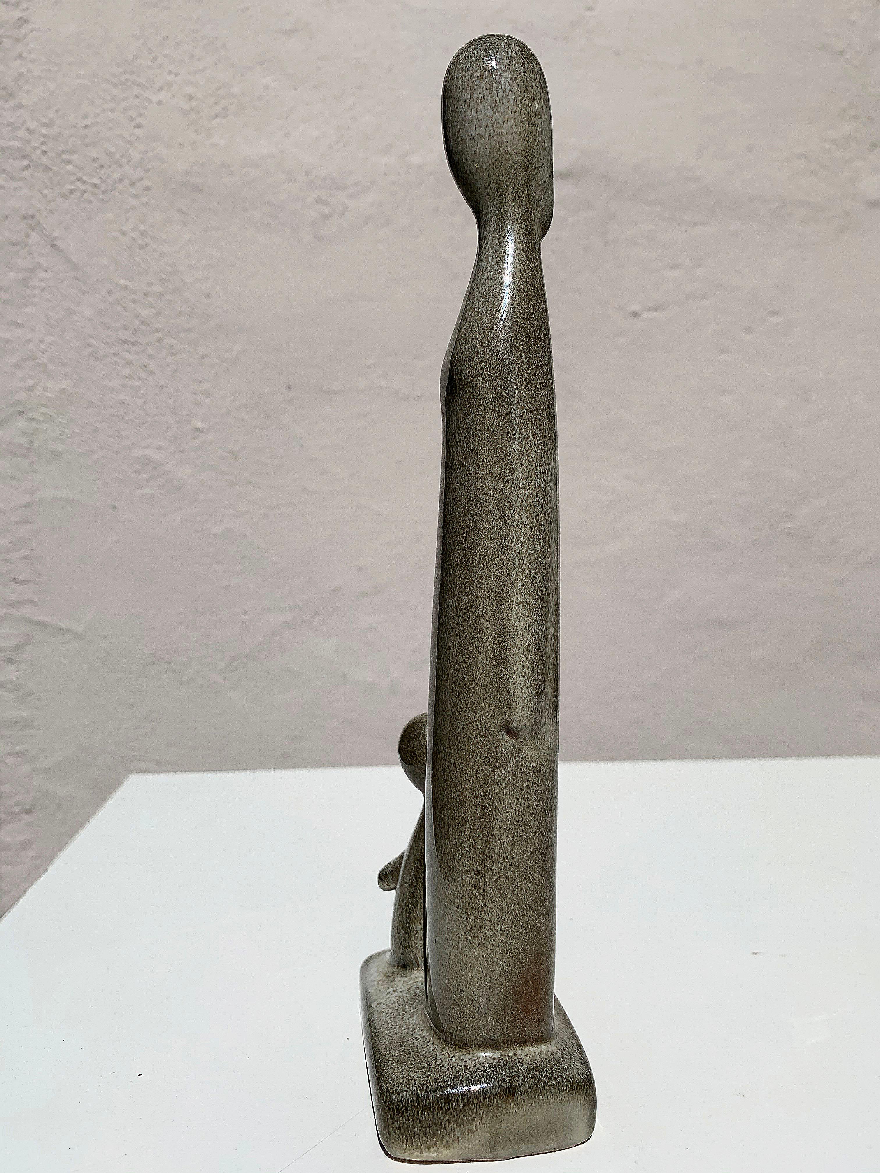 Mother and child ceramic sculpture by Howard Pierce. Howard Pierce graduated from the Art Institute of Chicago, later moving to California where he attended Pomona College. The glaze on this piece is a glossy tan. This piece is stamped with the