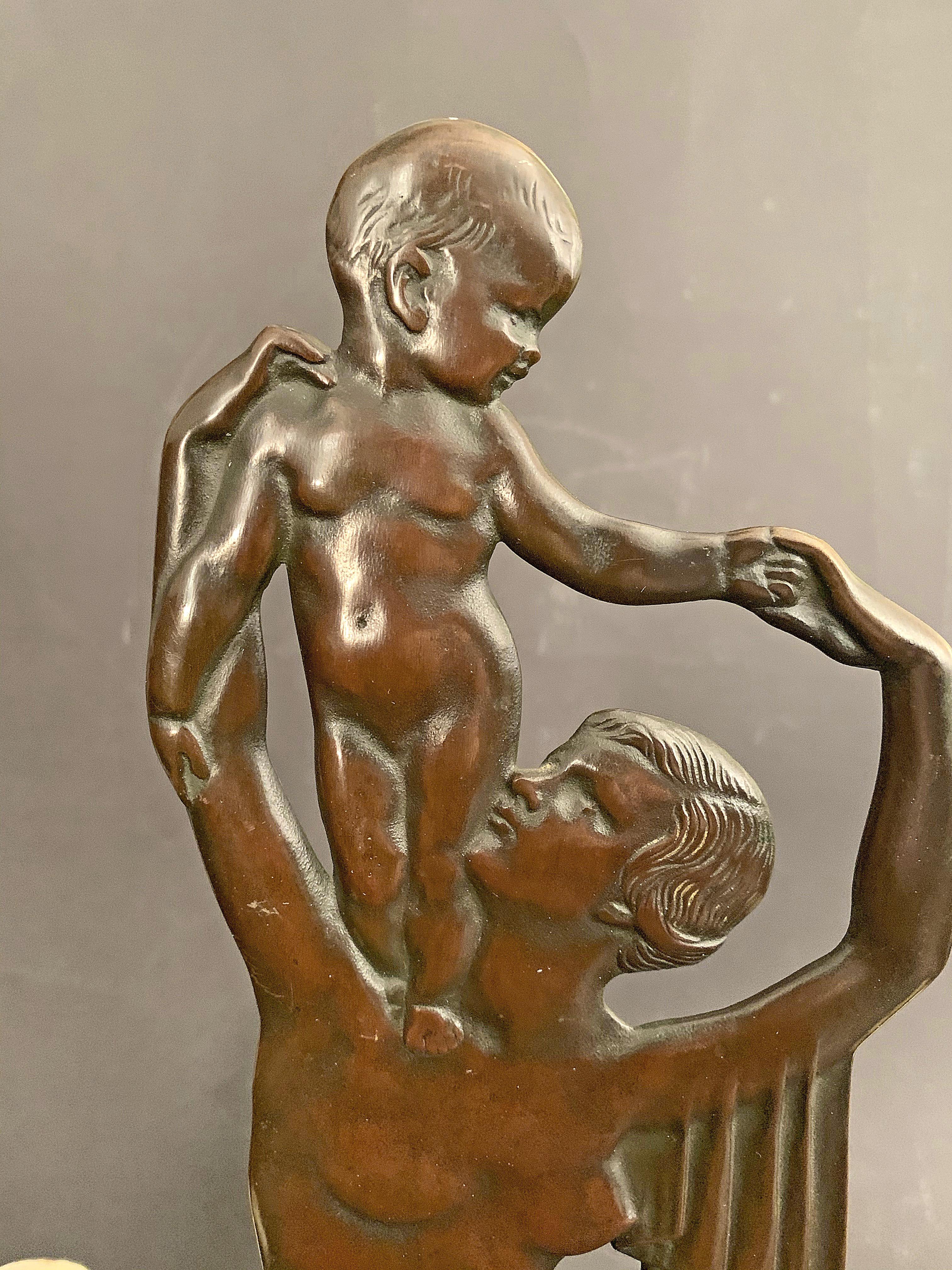 One of the most exquisitely beautiful bronzes sculptures we have ever offered, this extremely rare bronze centerpiece features a mother with her child standing on her shoulder, each figure beautifully modeled and executed. The sculpture is flanked