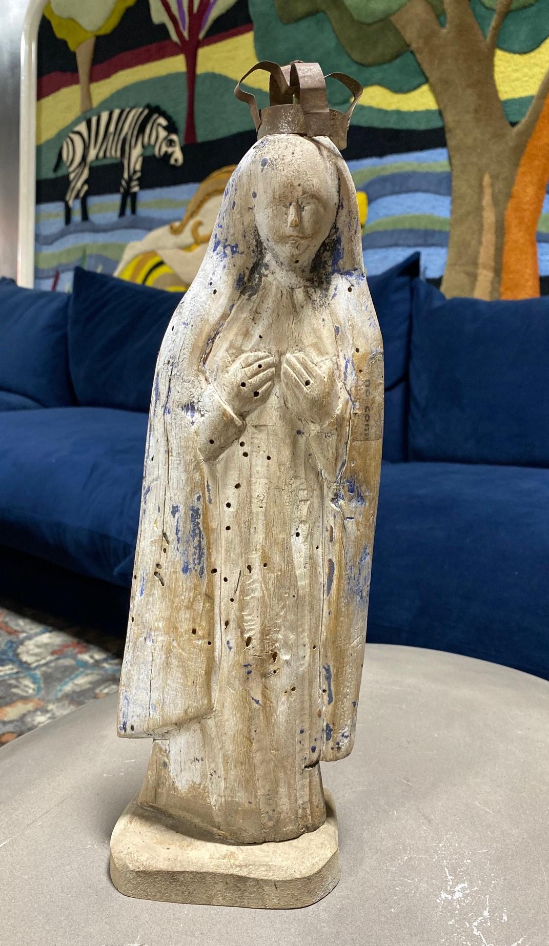 A beautiful hand-carved wood Santo of the Madonna, Mary mother of Christ. 

The piece clearly shows signs of weathering, use, and age and was likely placed outside a church or shrine for some years. The paint has faded leaving a quite attractive