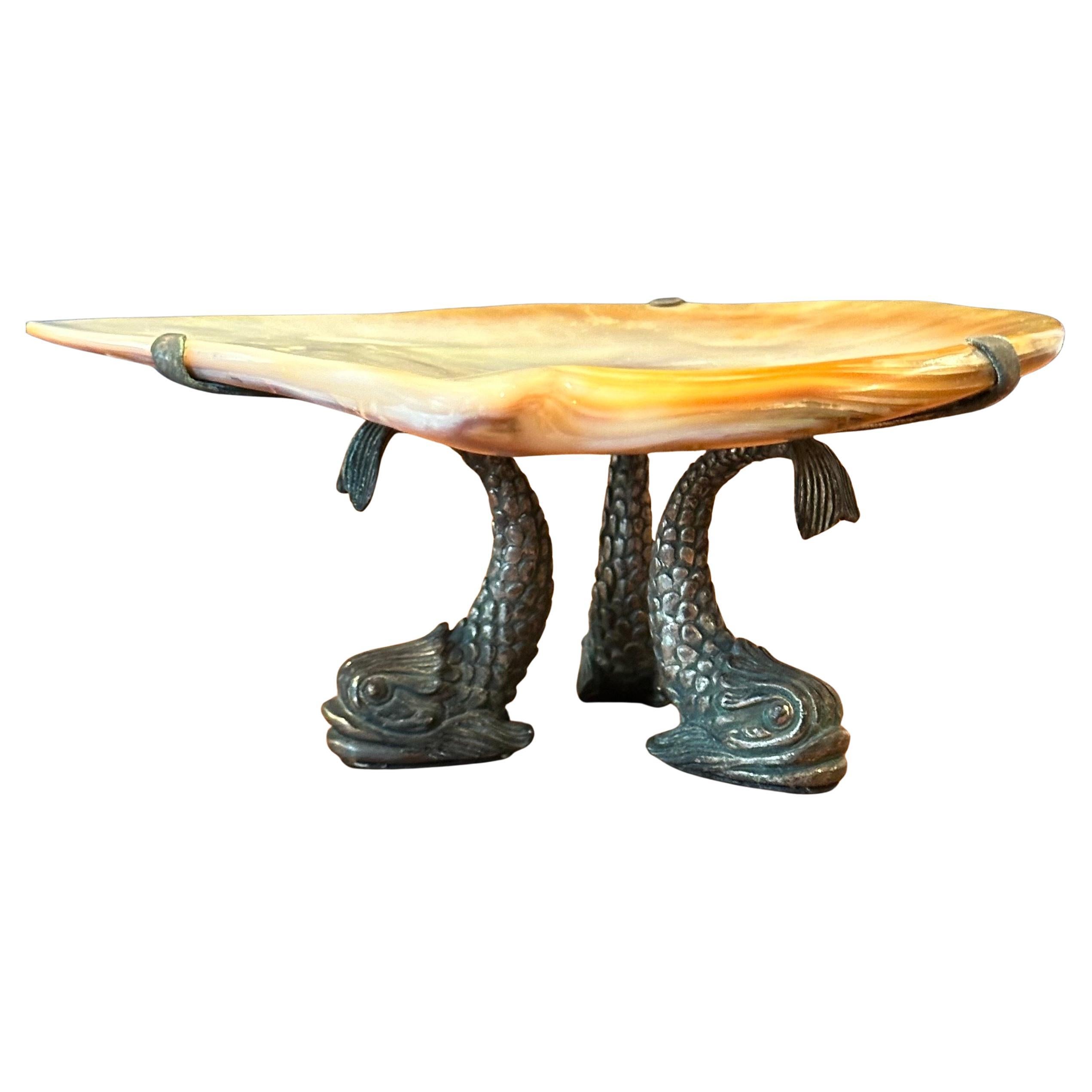 Preciosa caviarera de nácar y bronce de Maitland Smith, hacia la década de 1970.  La pieza presenta una concha MOP sobre una base de 3 peces de bronce y está en muy buen estado vintage, sin astillas ni grietas.  Preciosa artesanía y calidad en este
