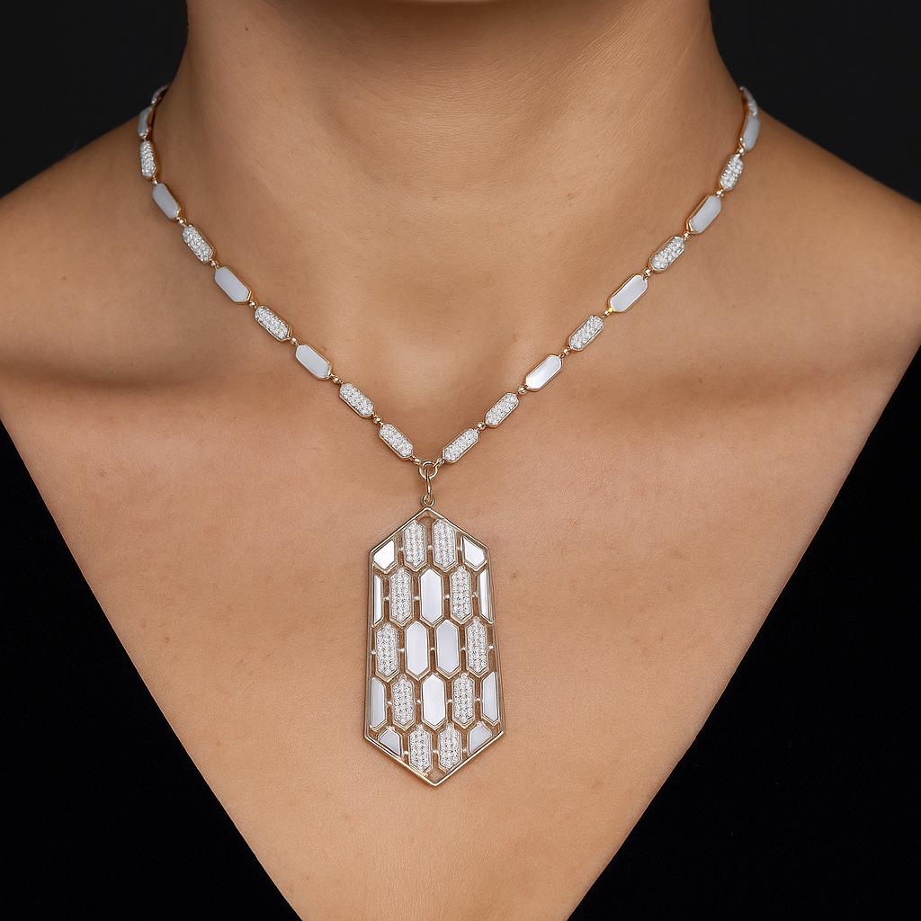 Este impresionante collar presenta un colgante hexagonal único con un elegante diseño inspirado en los panales de abeja. Elaborado con secciones alternas de nácar y diamantes engastados en pavé, el colgante brilla con cada movimiento, captando la