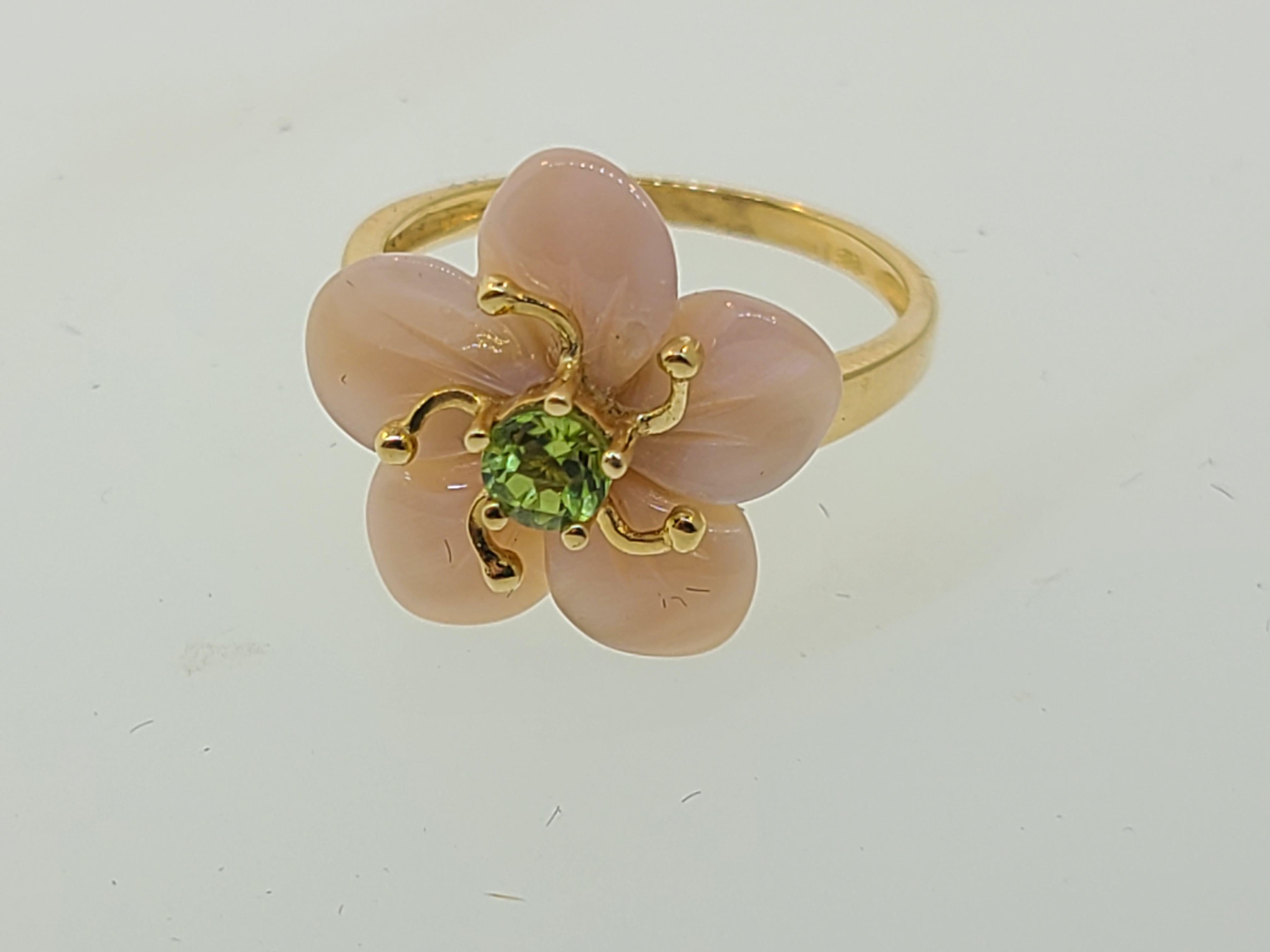 Dieser modische, zeitgenössische Blumenring ist aus 14-karätigem Gelbgold mit rosafarbenen Perlmuttblättern und einem Peridot im Rundschliff, der die Narbe der Blüte darstellt, sowie 14-karätigen Goldakzenten, die die Staubbeutel der Blüte