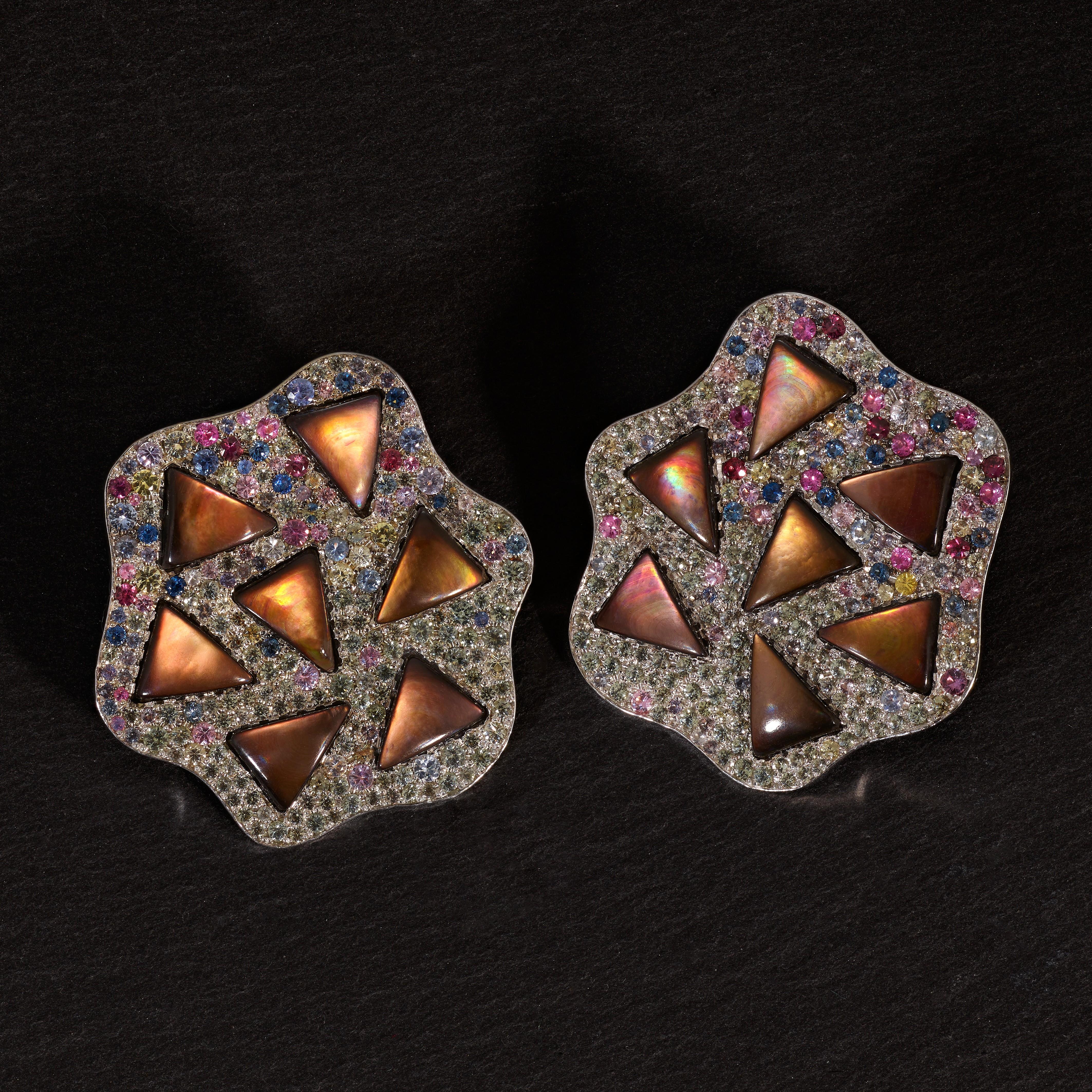 A unique creation by the Portuguese house Rosior, these earrings are set in 19,2k White Gold with:
- 14 Triangular pieces of Black Mother-of-Pearl, with hues of brown weighing 8,05 ct;
- 428 multicolor Sapphires weighing 4,26 ct.
Weight of 19,2k