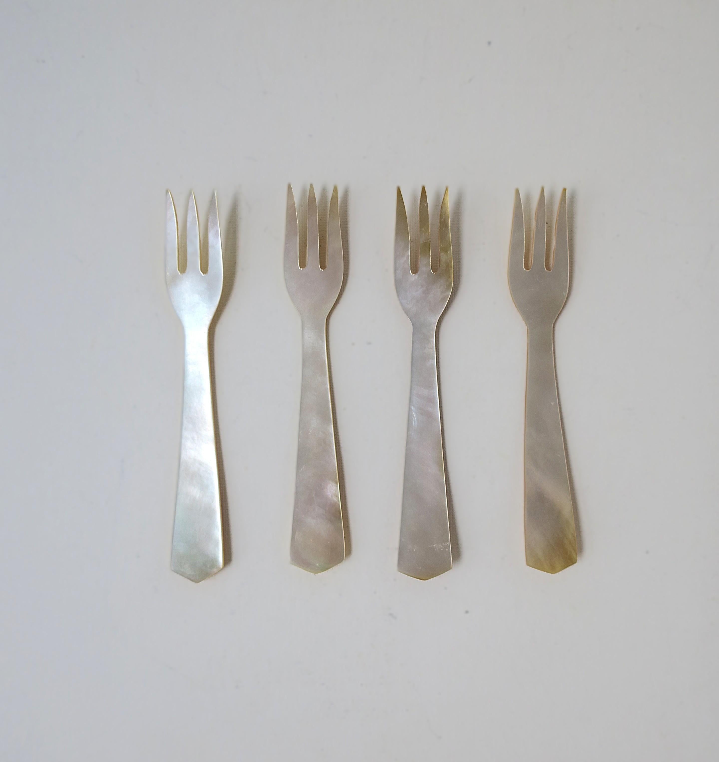 A beautiful set of four (4) Mother of Pearl caviar appetizer forks. Last image shows reverse side of shell. A beautiful set that could also make a nice gift. 