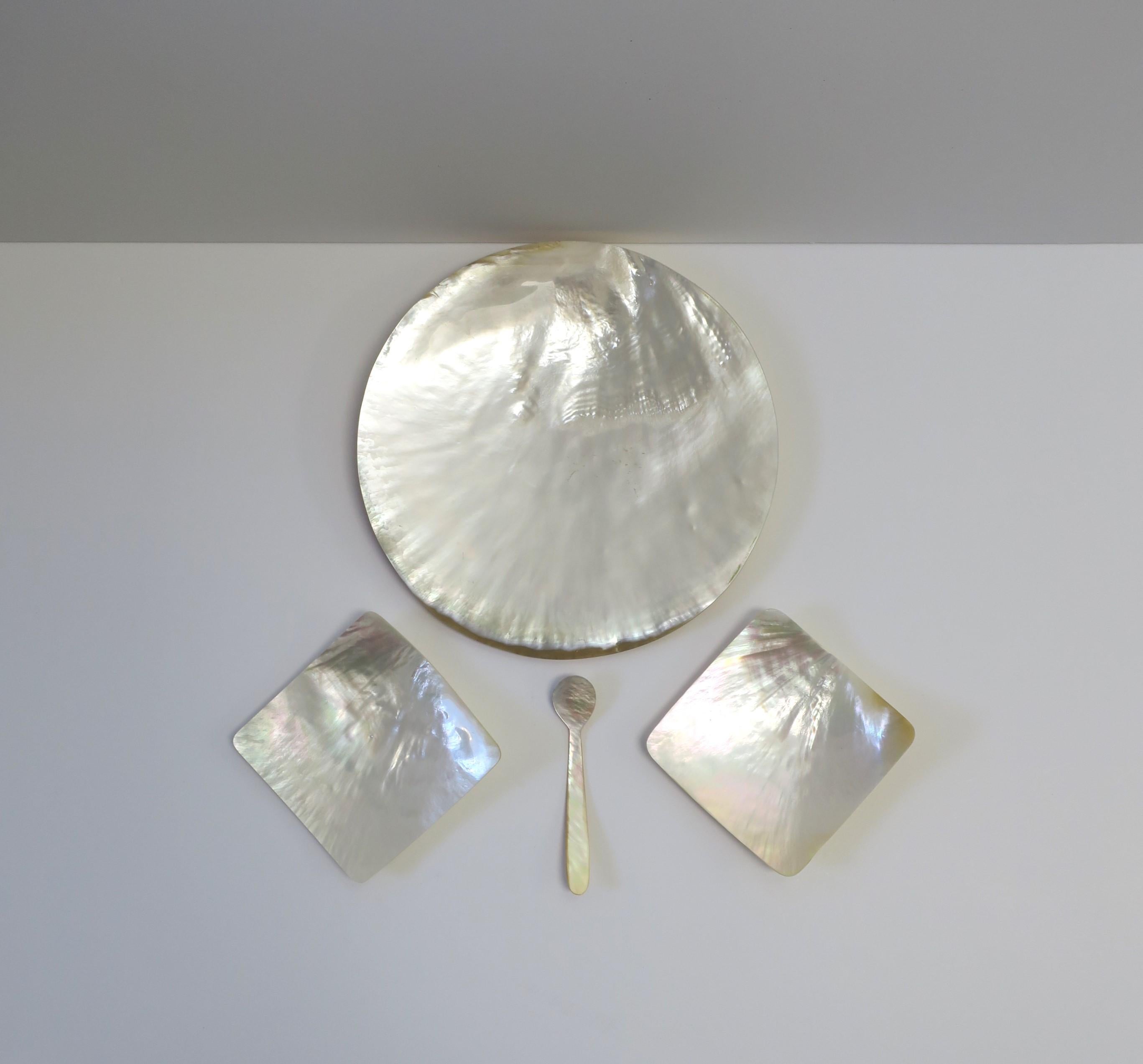 A beautiful Mother of Pearl caviar dish and spoon set, circa 20th century. This Mother-of-Pearl set includes four (4) pieces; 1 round dish, 2 square dishes, and 1 spoon. 

Dimensions: 
Round dish: 8.44