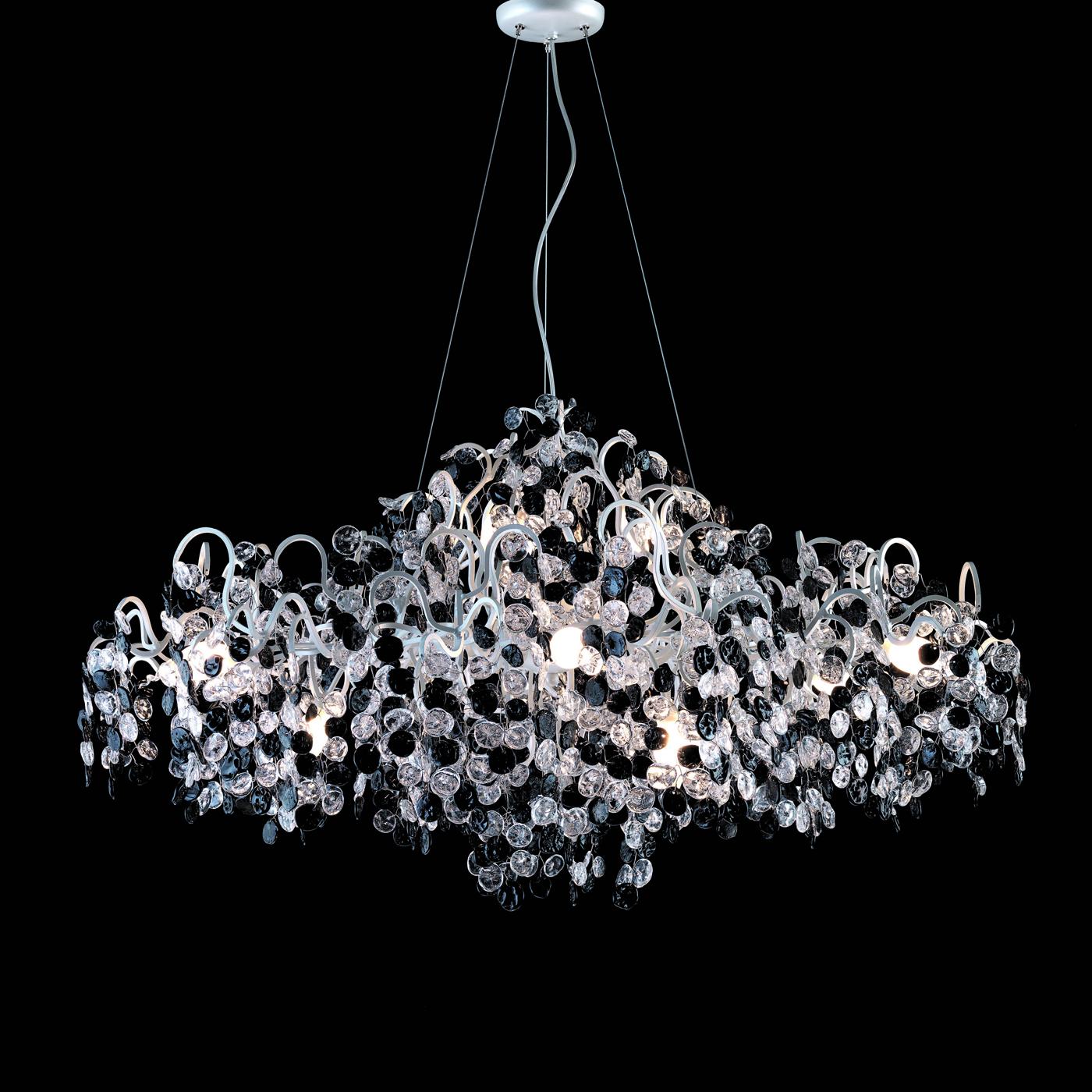An opulent and breathtaking masterpiece both when lit and off, this chandelier features a main, sinuous metal frame hosting the 12 ES bulbs (G9 and max. 33W each) whose light refracts onto the Cascade of nacreous petals alternated with black and