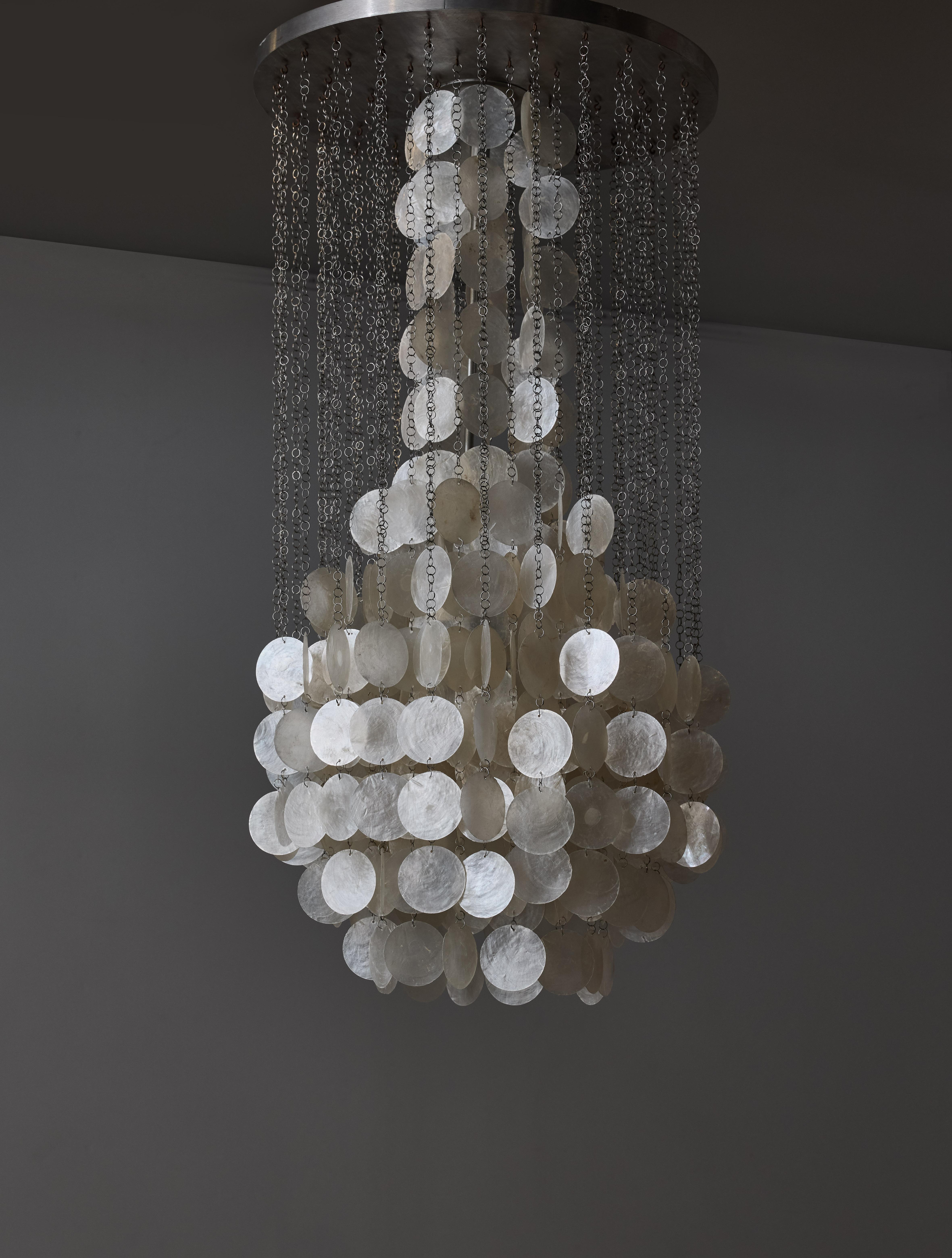 Beautiful chandelier made of a round aluminium ceiling plate, from which fall tens of mother of pearl discs, linked amongst them with adjustable chains.

The sources of light are hidden in the central 