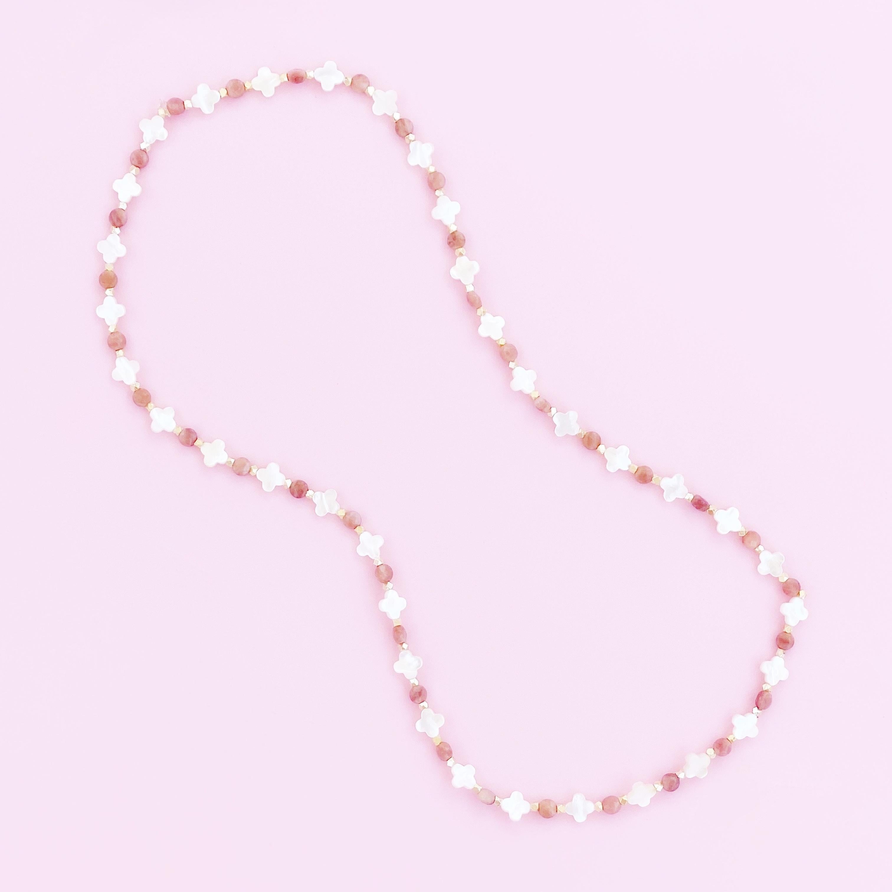 Clover shaped Mother of Pearls flanked by Pink Aventurine gemstones and gold-plated accents on stretchy elastic cord.

30