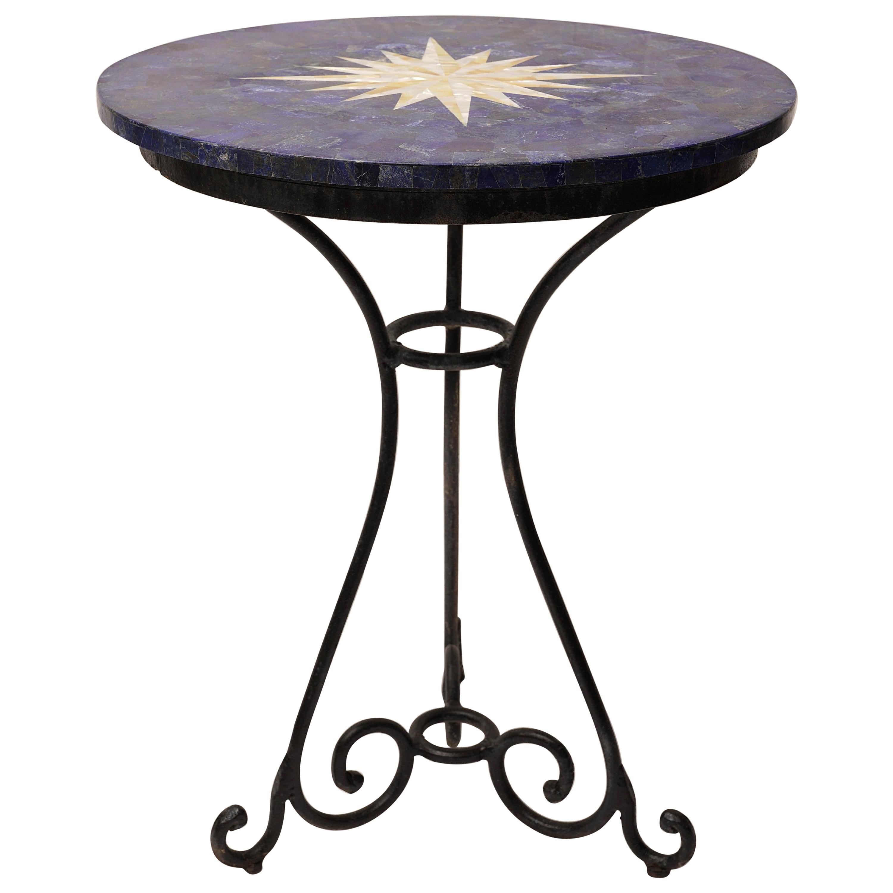 An amazing pietra dura table of lapis lazuli complemented with an inlaid mother of pearl compass rose on the top. Sits on a hand-wrought iron base. Many versatile uses as a dining cafe table, centre table, side table, etc.   Use inside or out.

I