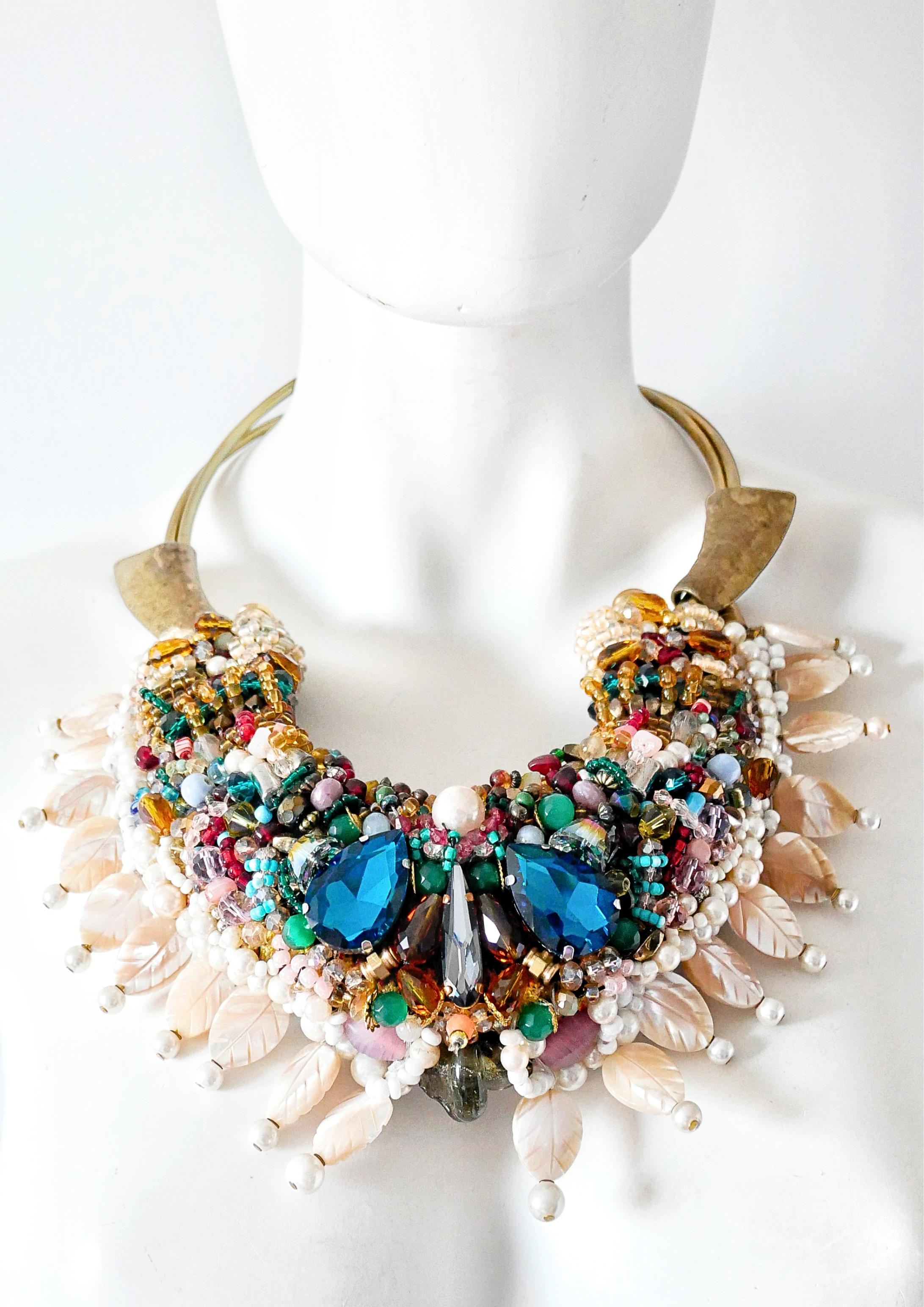 Introducing to you a mother of pearl, crystals and gemstone beaded statement collar and bib necklace. Unique and captivating, this necklace style is a masterpiece of artisanry, with an intricate design featuring rare glass beads of various colours,
