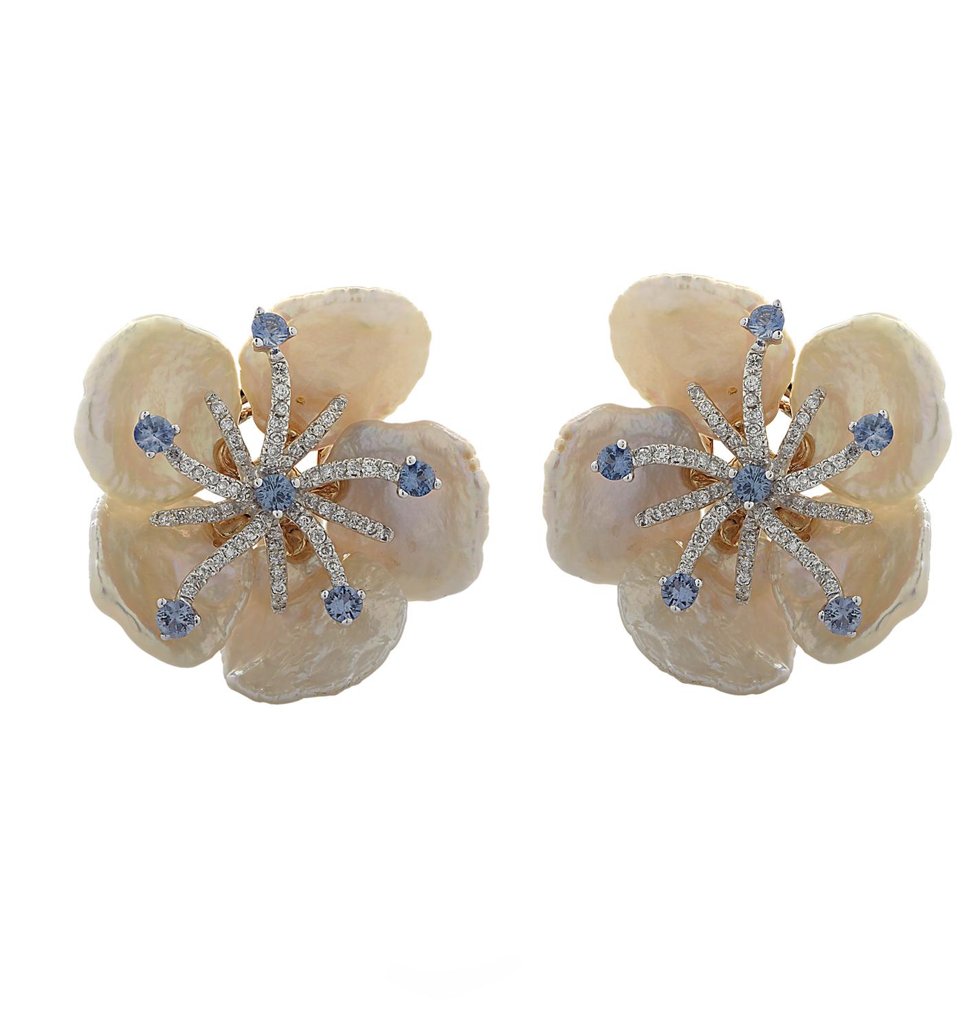 Enchanting flower earrings, crafted in 18 karat yellow gold and Mother of Pearl, featuring 140 round brilliant cut diamonds weighing approximately 1 carat total, G color, VS clarity and 12 blue sapphires weighing approximately 1 carat total.