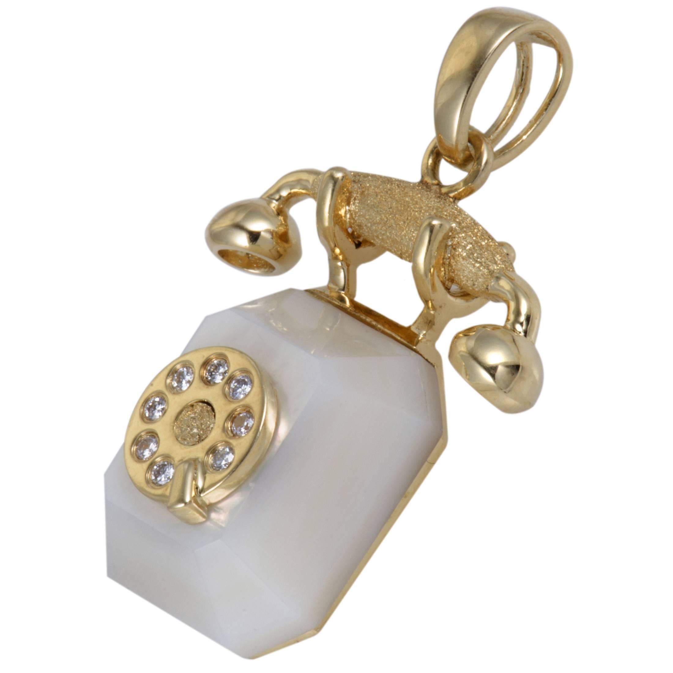 Gorgeously designed and wonderfully decorated, this splendid pendant boasts a nifty charming appeal. Made in shimmering 18K yellow gold in the shape of a rotary telephone, the incredible pendant is spectacularly embellished in the ever elegant