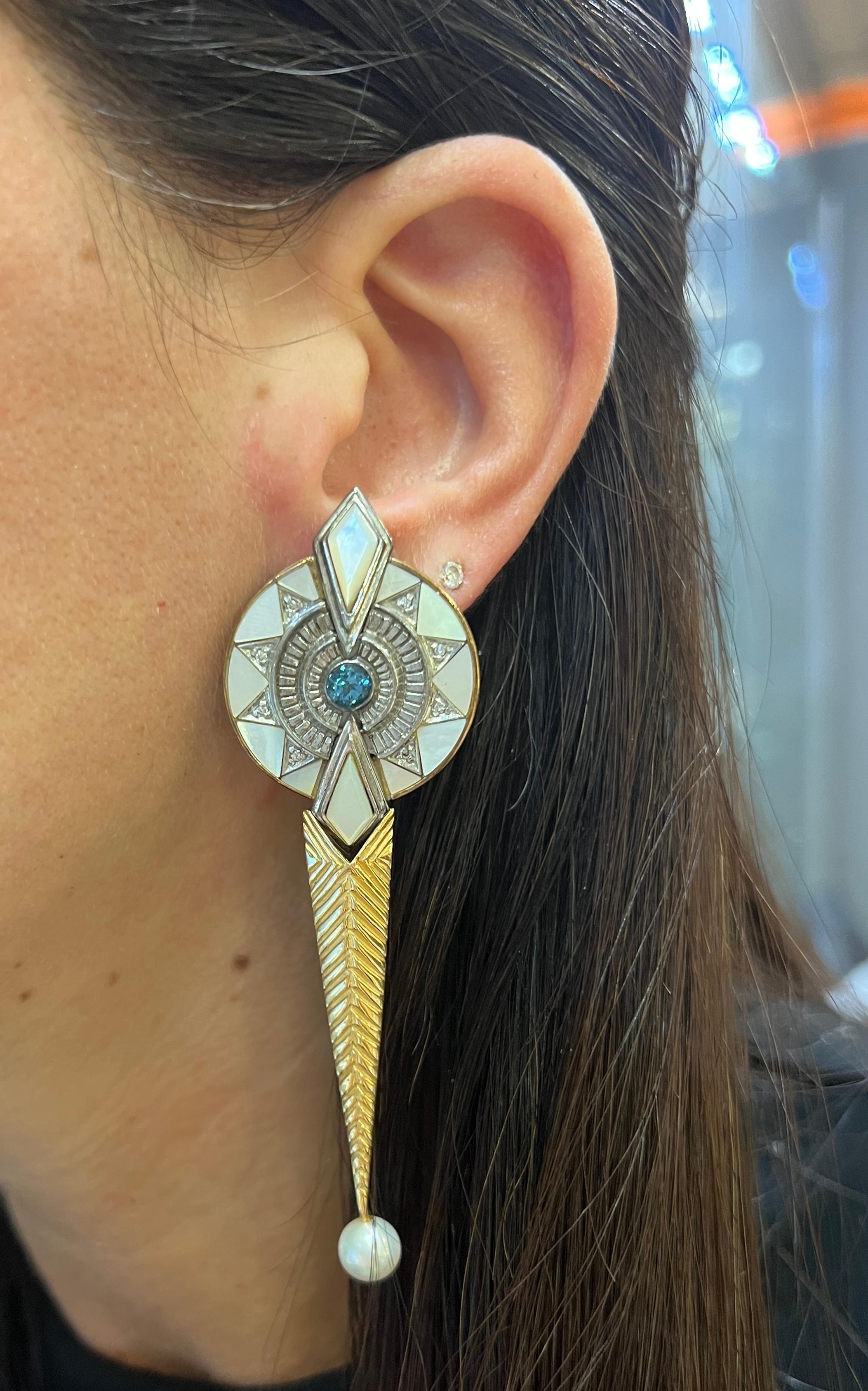 

A pair of earrings set with mother-of-pearl inlays, round-cut topaz, diamonds, and a pearl drop.

Approximate Length: 2.5