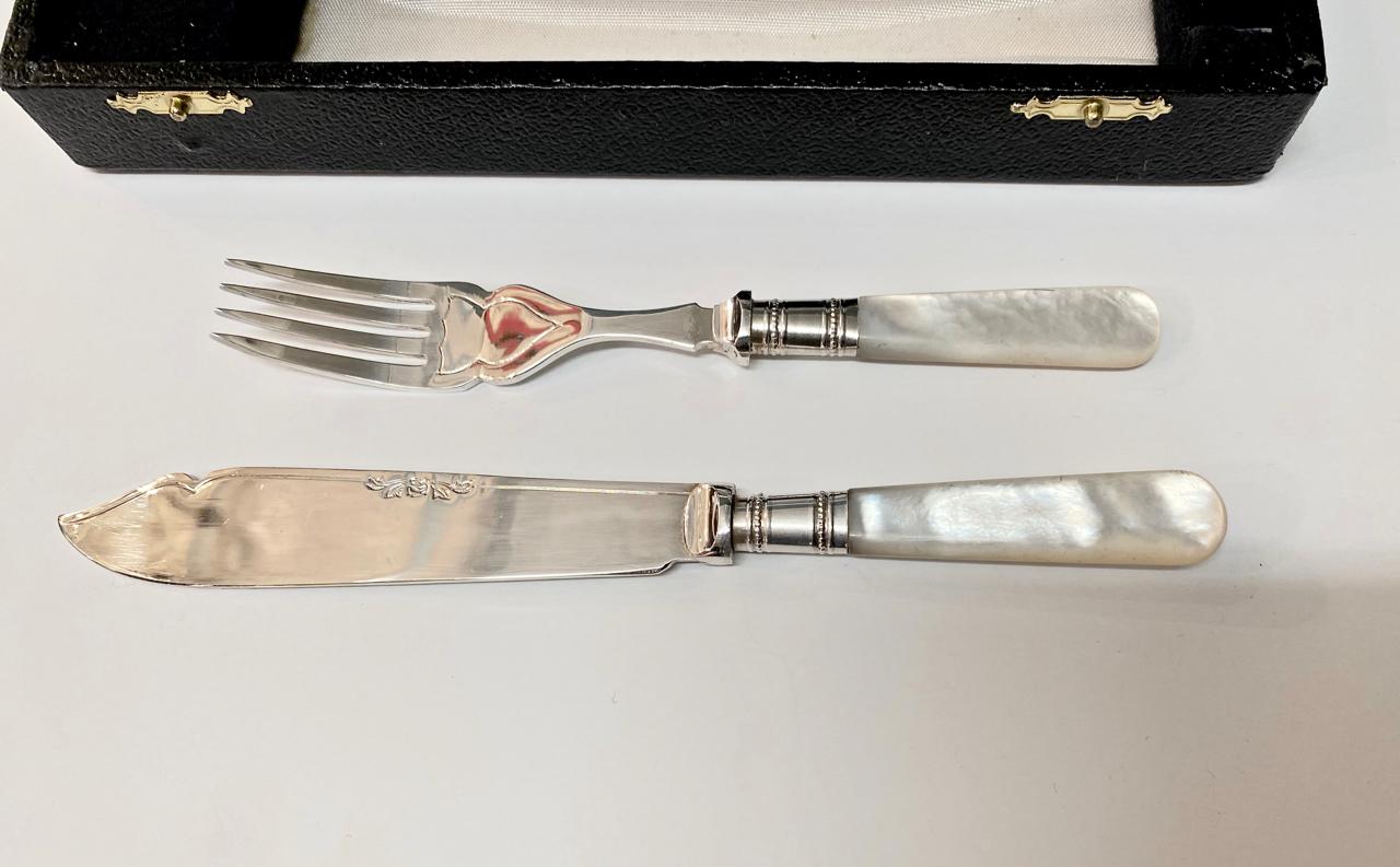 This is a Classic mother of pearl handled fish knives and forks. All 12 pieces are in overall very good condition and date to the early 20th century. The flatware is adorned with sterling collars; the knife blades are engraved with a floral design.