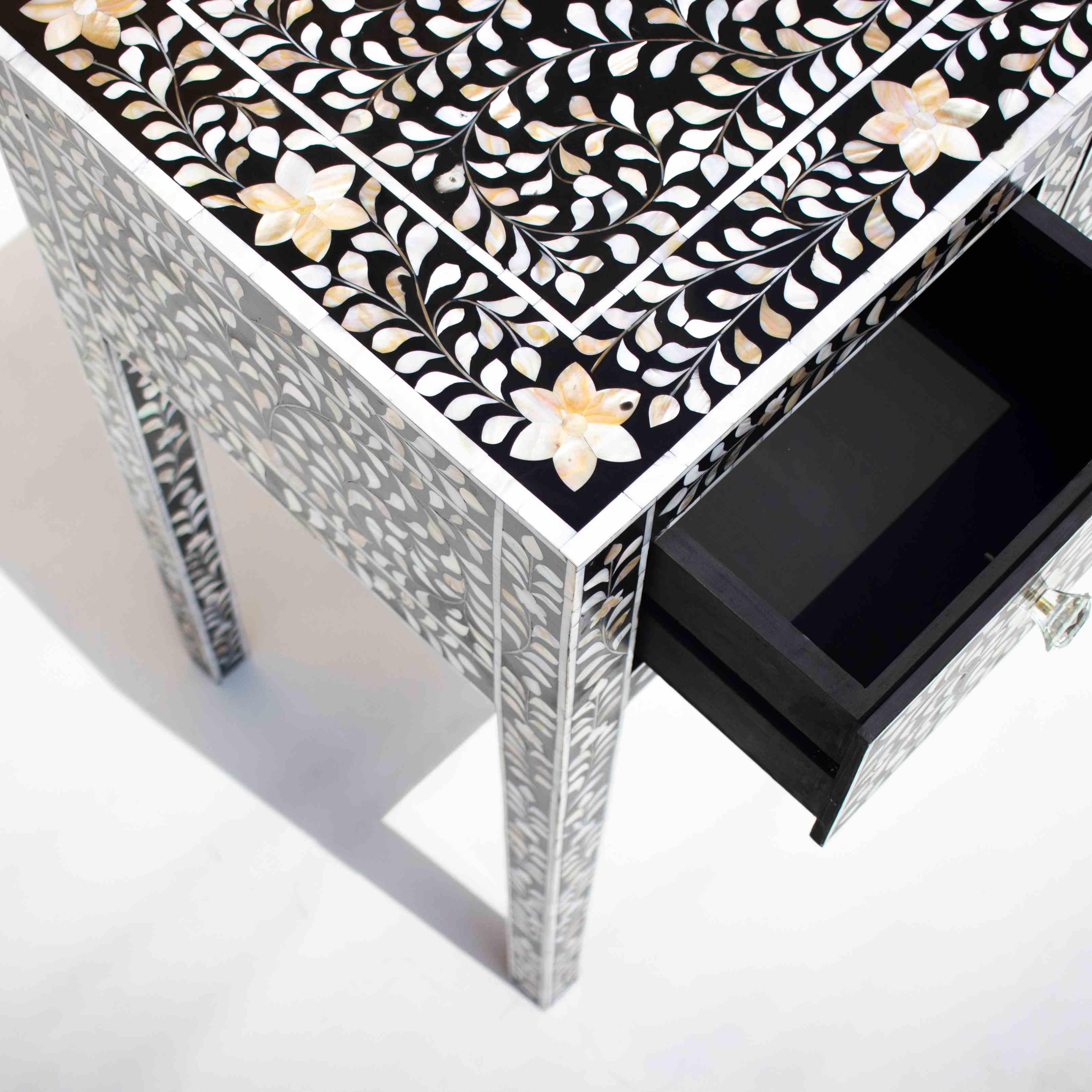 Introducing our exquisite black mother of pearl inlay desk, a statement piece that seamlessly merges timeless elegance with modern functionality. Adorned with intricate flower patterns, this desk pays homage to the ancient art form of decorated