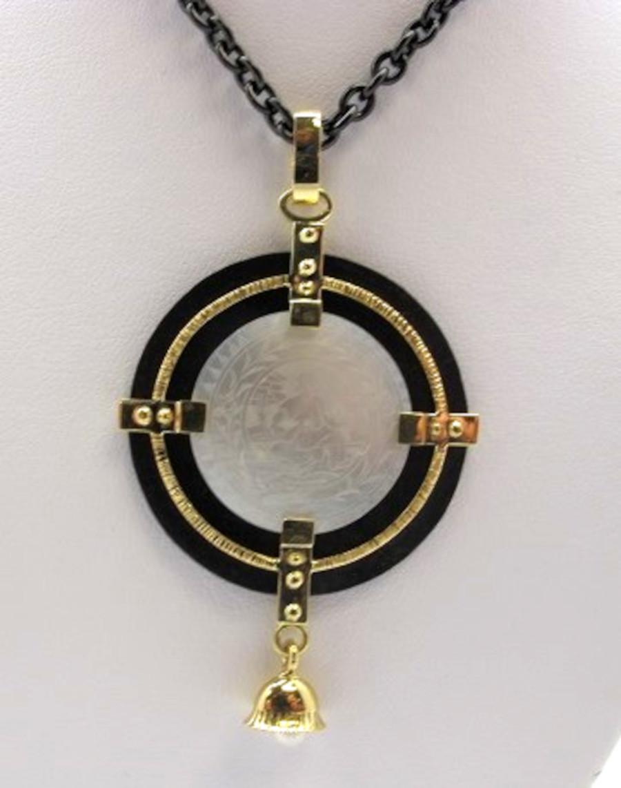 This beautiful necklace features an antique, mother-of-pearl Chinese gambling counter dating back to the 18th Century. The round gaming counter is framed in rich 18k yellow gold and blackened silver, in an eye-catching design that looks gorgeous