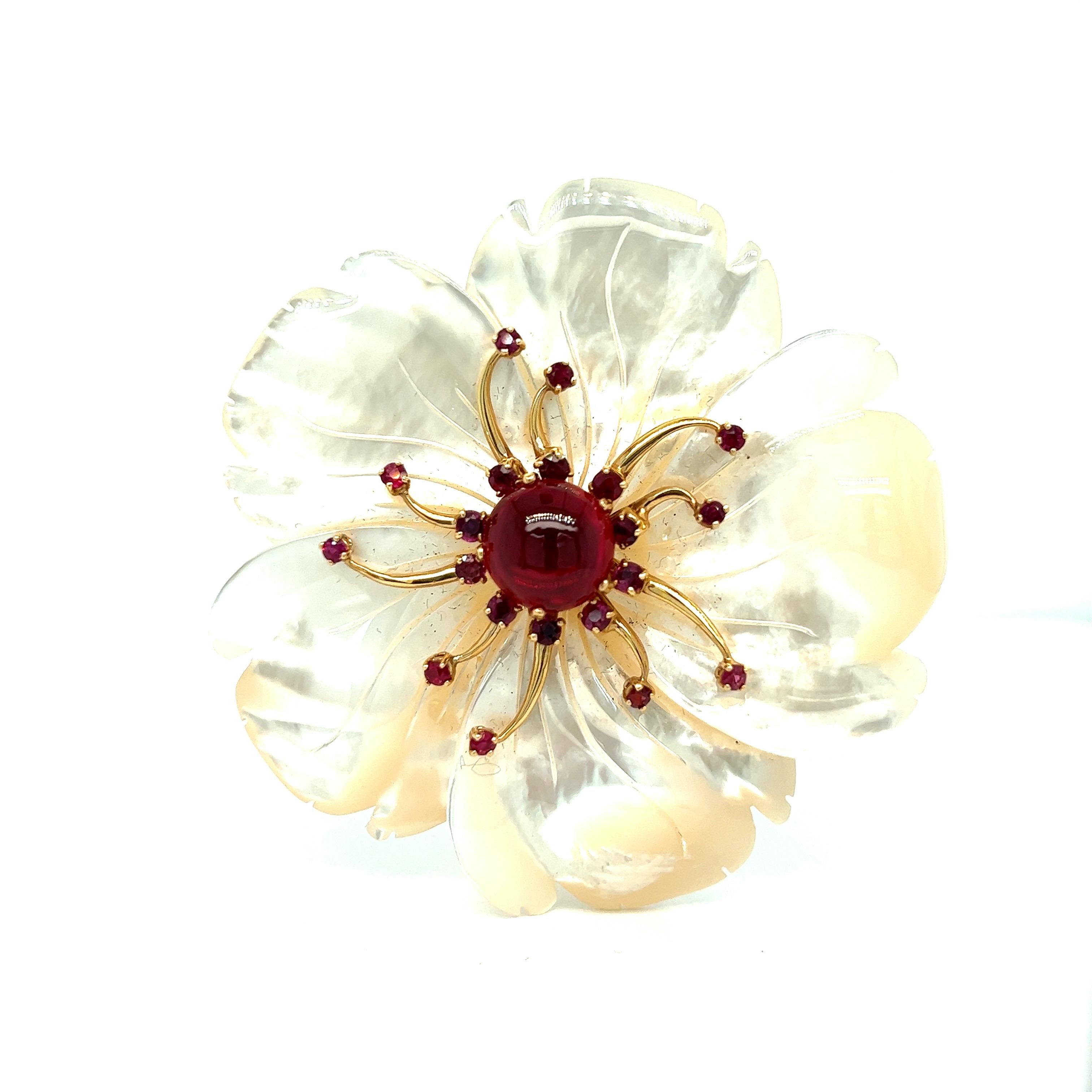 Mother of pearl garnet flower brooch

Center stone cabochon garnet (12 mm) of approximately 10-12 carats, mother of pearl petals, 18 karat yellow gold; marked 18K

Size: width 2.75 inches, length 2.75 inches
Total weight: 55.2 grams