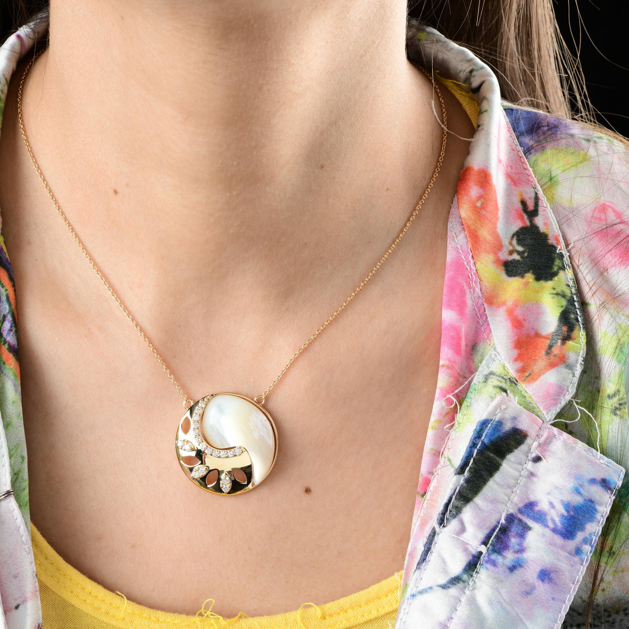 La breloque en nacre est délicatement suspendue à une chaîne en or jaune 14 carats, ajoutant chaleur et éclat à l'ensemble du design. La fabrication artisanale garantit le souci du détail et crée une touche personnalisée, faisant de chaque collier