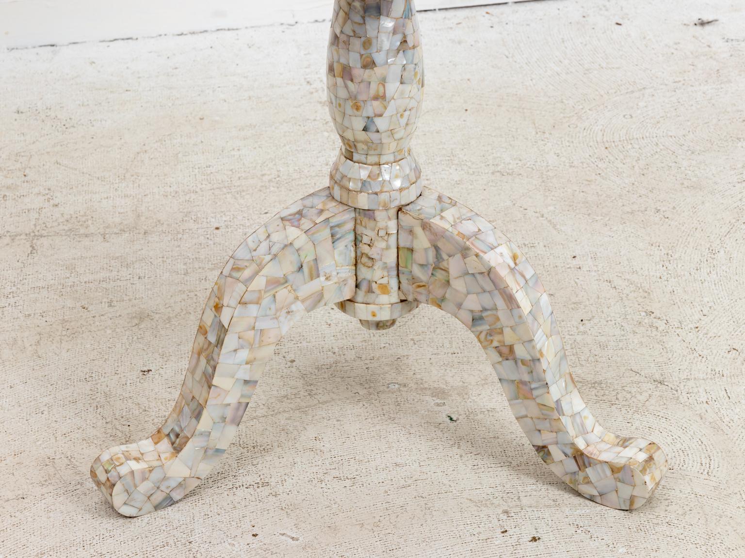 Mother of pearl inlaid side table on tripod pedestal base. The piece is overlayed with various sized fragments of mother of pearl throughout. Please note wear consistent with age.