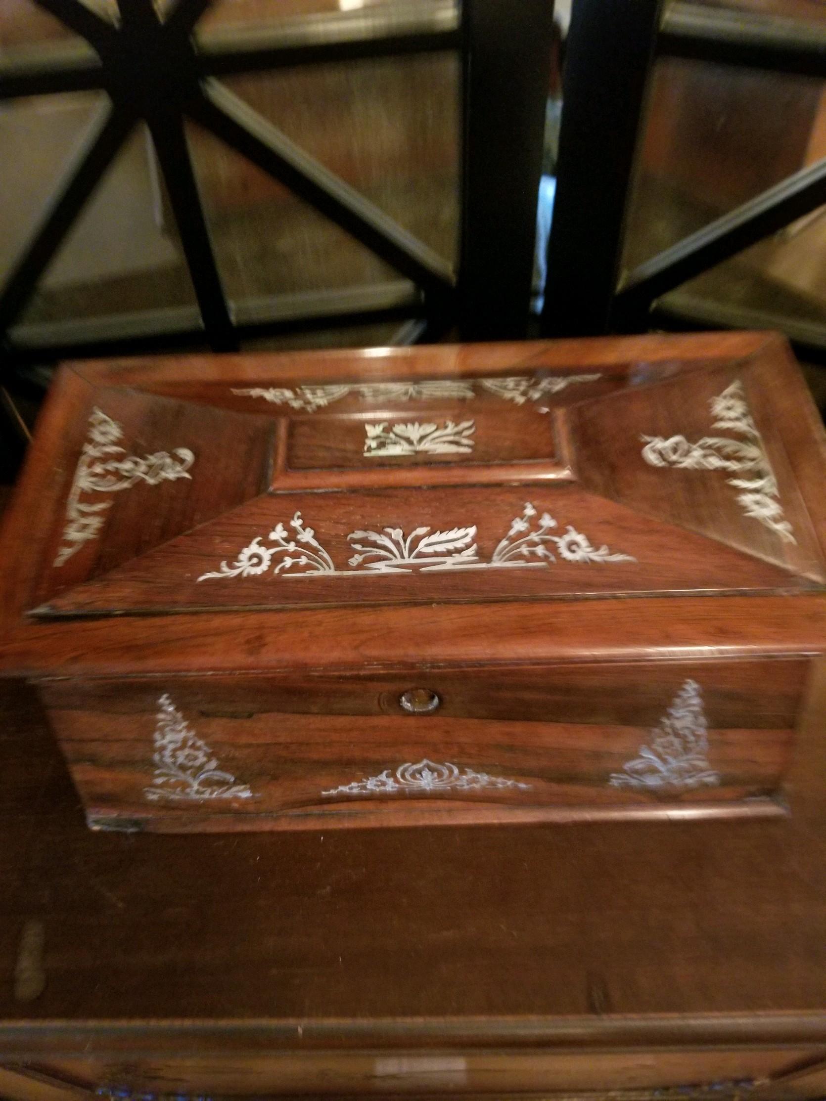 Beautifully executed, this mother of pearl inlay tea caddy does it all. In good condition, it has all of its parts: The individual containers and even a footed waste bowl. The details surround the box and is a wonderful presentation piece. In good