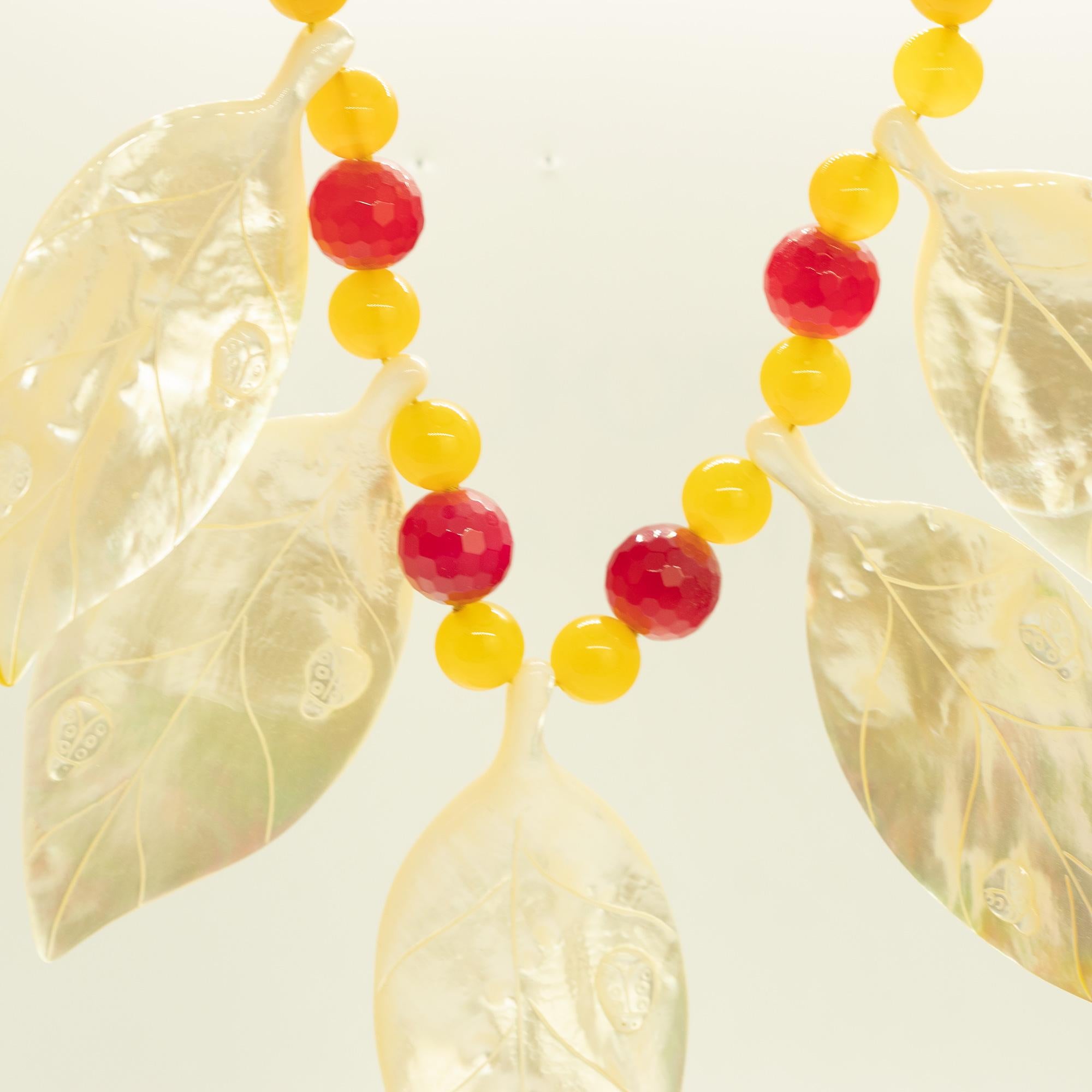 Le splendide madreperle intagliate su una collana colorata creano un eccezionale design Made in Italy.

- Chiusura a moschettone in argento Sterling 925
- Foglie di madreperla 9,5 x 4,5 cm
- Agata gialla di 1,2 cm di diametro
- Agata lilla