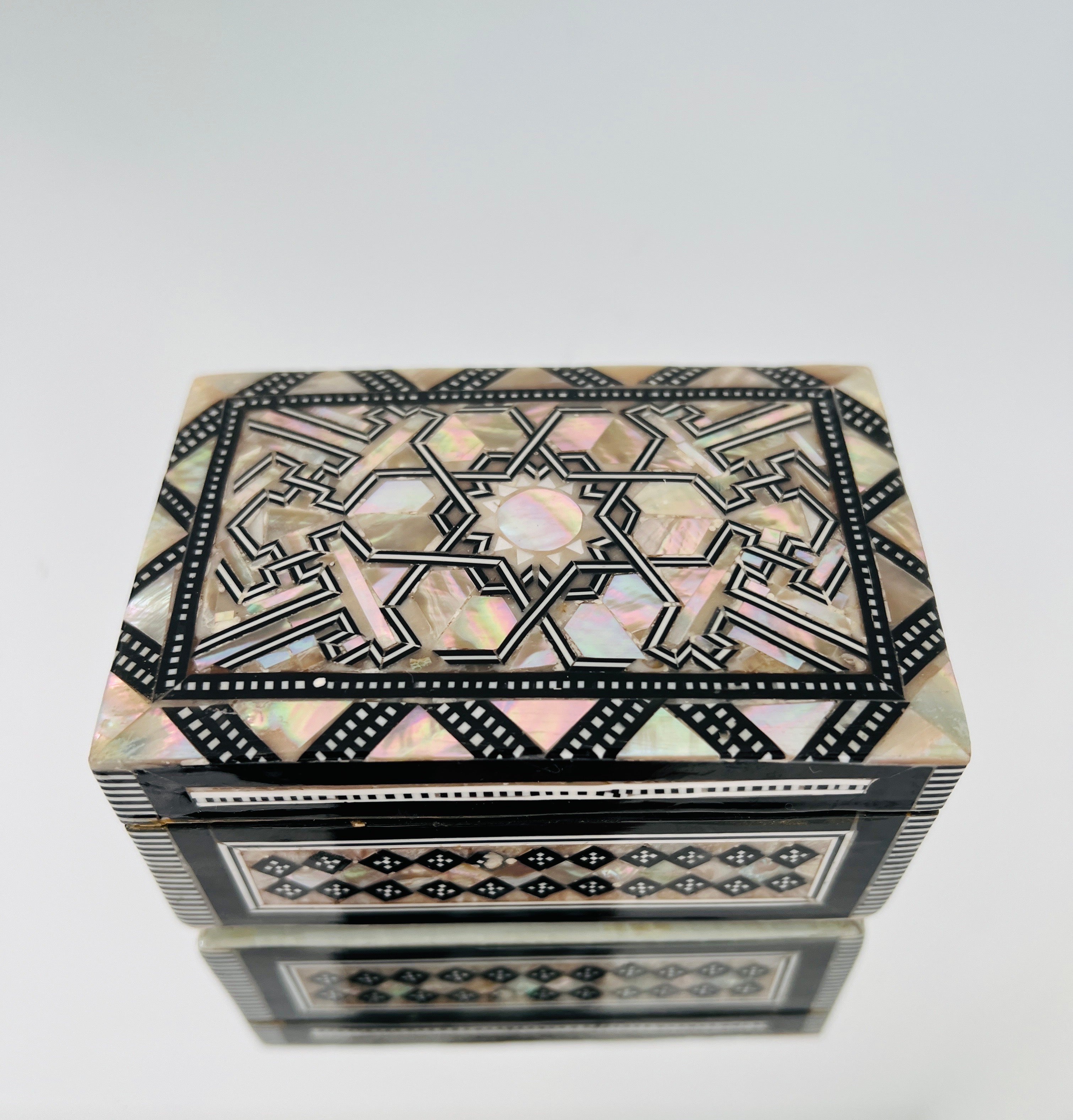 Exquisite handcrafted geometric wood box with micro mosaic inlays of mother of pearl in Khatam artistry, an Ancient Persian technique of inlaying. Moorish style box also features geometric bone inlays over wood with a hinged lid and interior lined