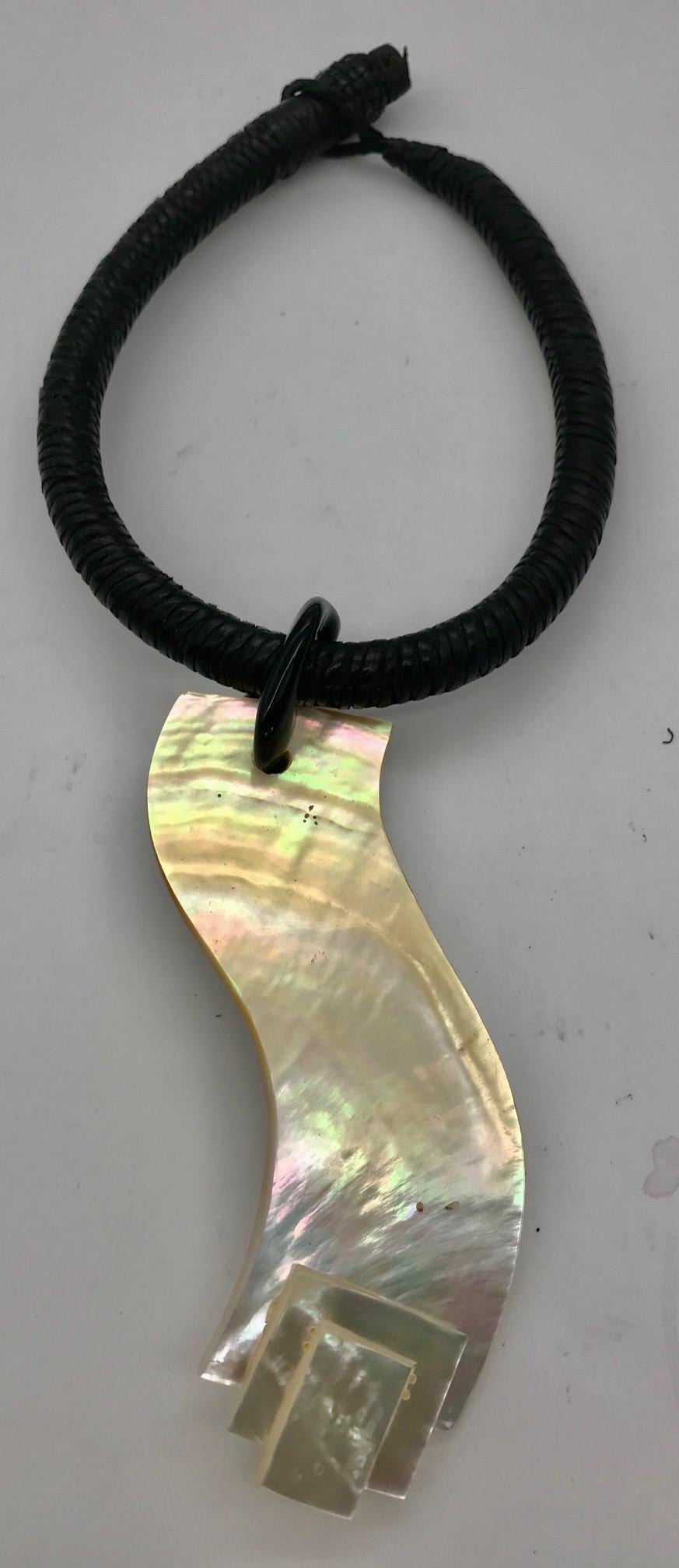 Mother of Pearl Pendant ,organic /architectural shape, with French Deco enhancer hung on a woven leather African necklace.White mother of pearl is called Pinctada Maxima and it can be seen in Photo Gallery.	.
 Nacreous oysters create a pearl, which