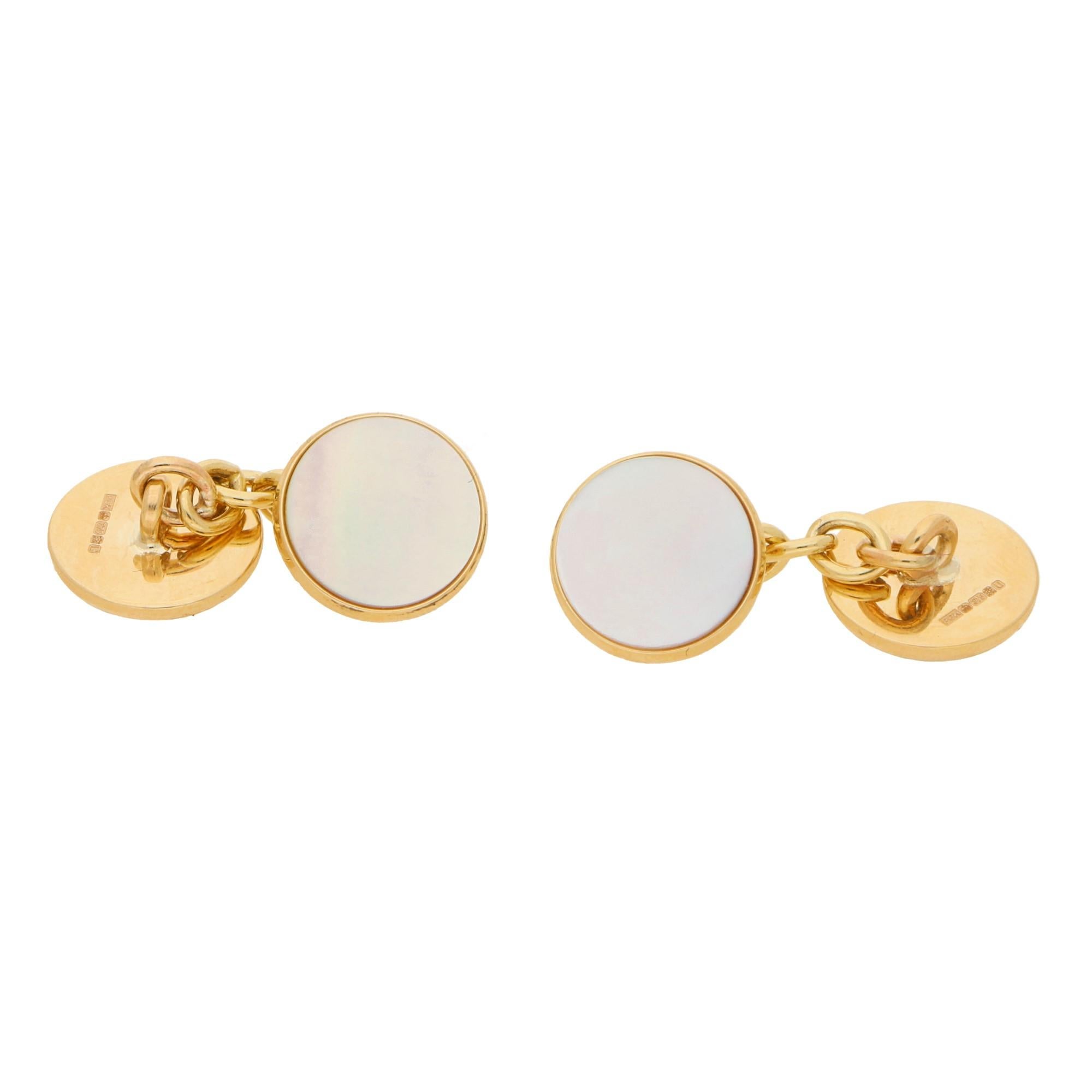A stylish pair of mother of pearl round chain cufflinks set in 9k yellow gold. 

Each cufflink solely features and single piece of lustrous white mother of pearl. The mother of pearl is set on-top of a solid 9k yellow gold disc which is connected to