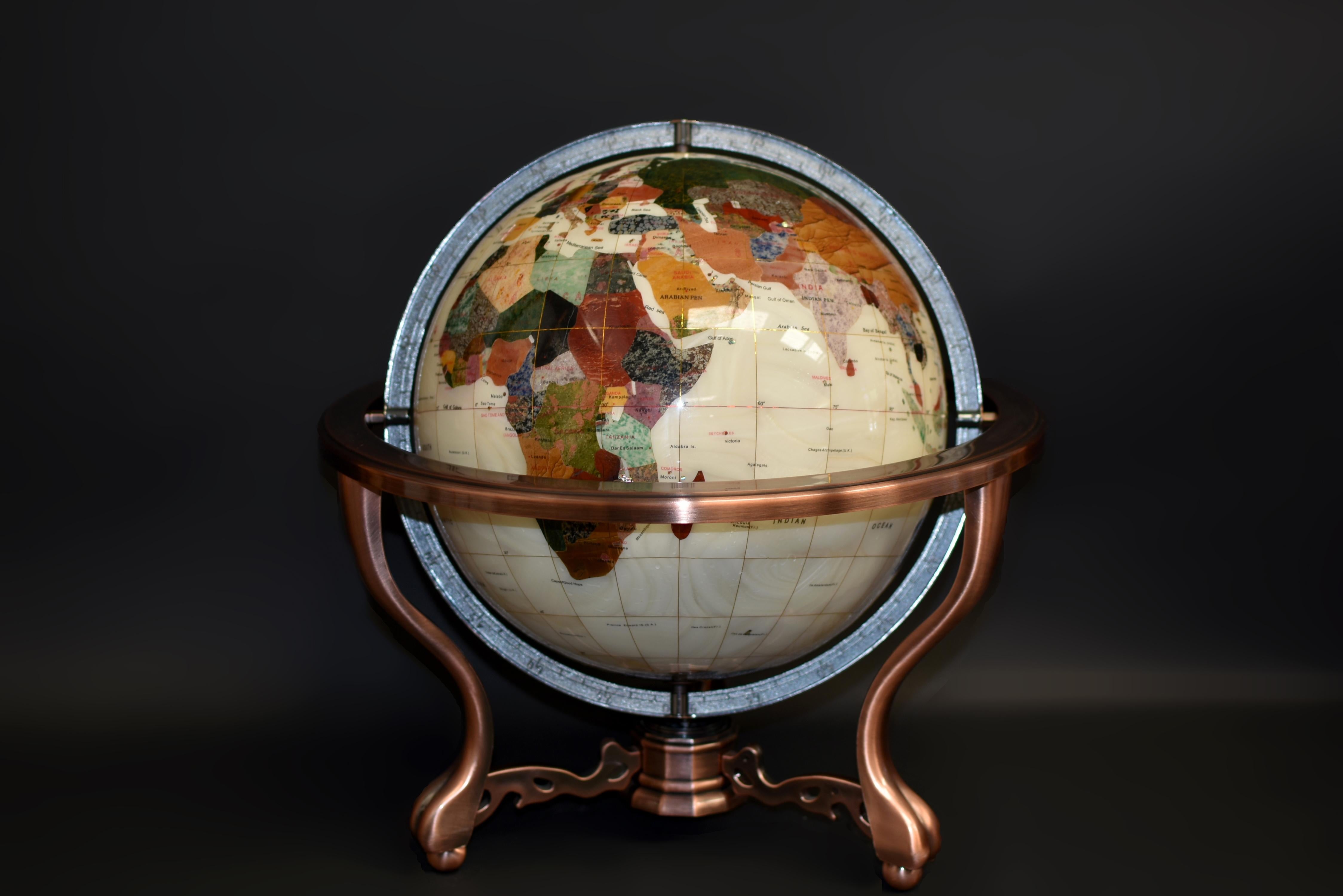 This large, exquisite mother of pearl globe is a luxurious masterpiece, adorned with a fantastic collection of semi-precious gemstones including lapis, jasper, turquoise, agate, aventurine, serpentine, onyx, rose quartz and many more. The globe