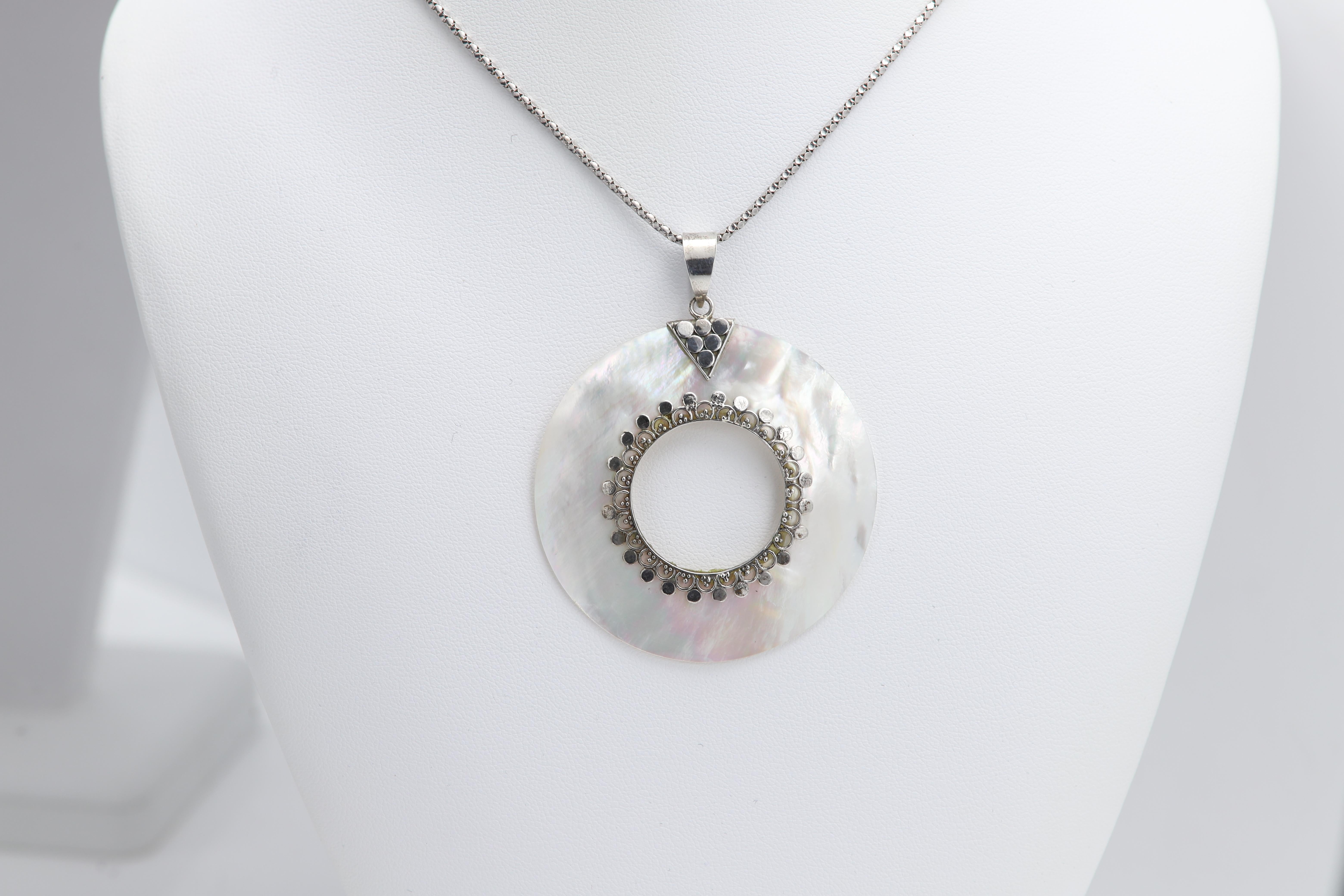 Vintage Pendant (new never used)
Natural Mother of pearl Shell
Circle Shape
Sterling Silver 925 with ornament design.
Weight: 11.30 grams
Size: Diameter 2' inch
Chain: silver snake style  16' inch